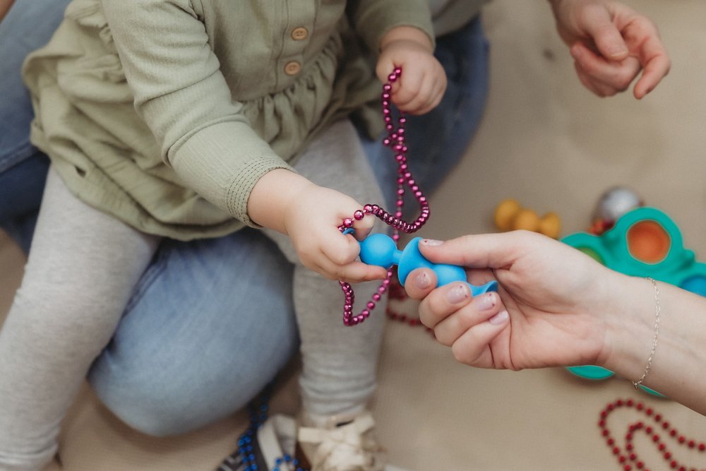  a child accepts a toy from an adult’s hand from a business session with a central illinois photographer 