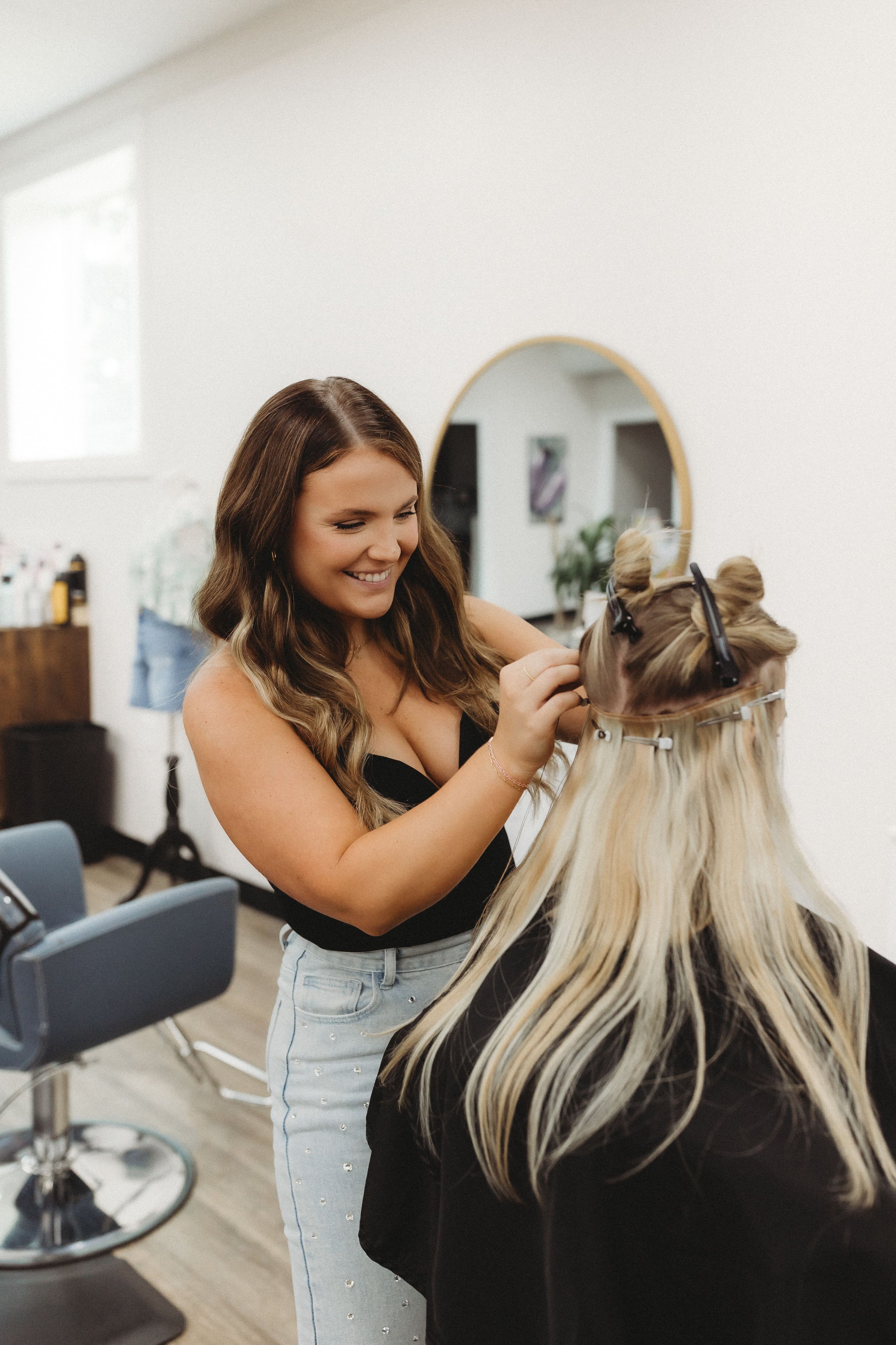  a hair stylist smiles during a photoshoot where she shows her specialty in action 