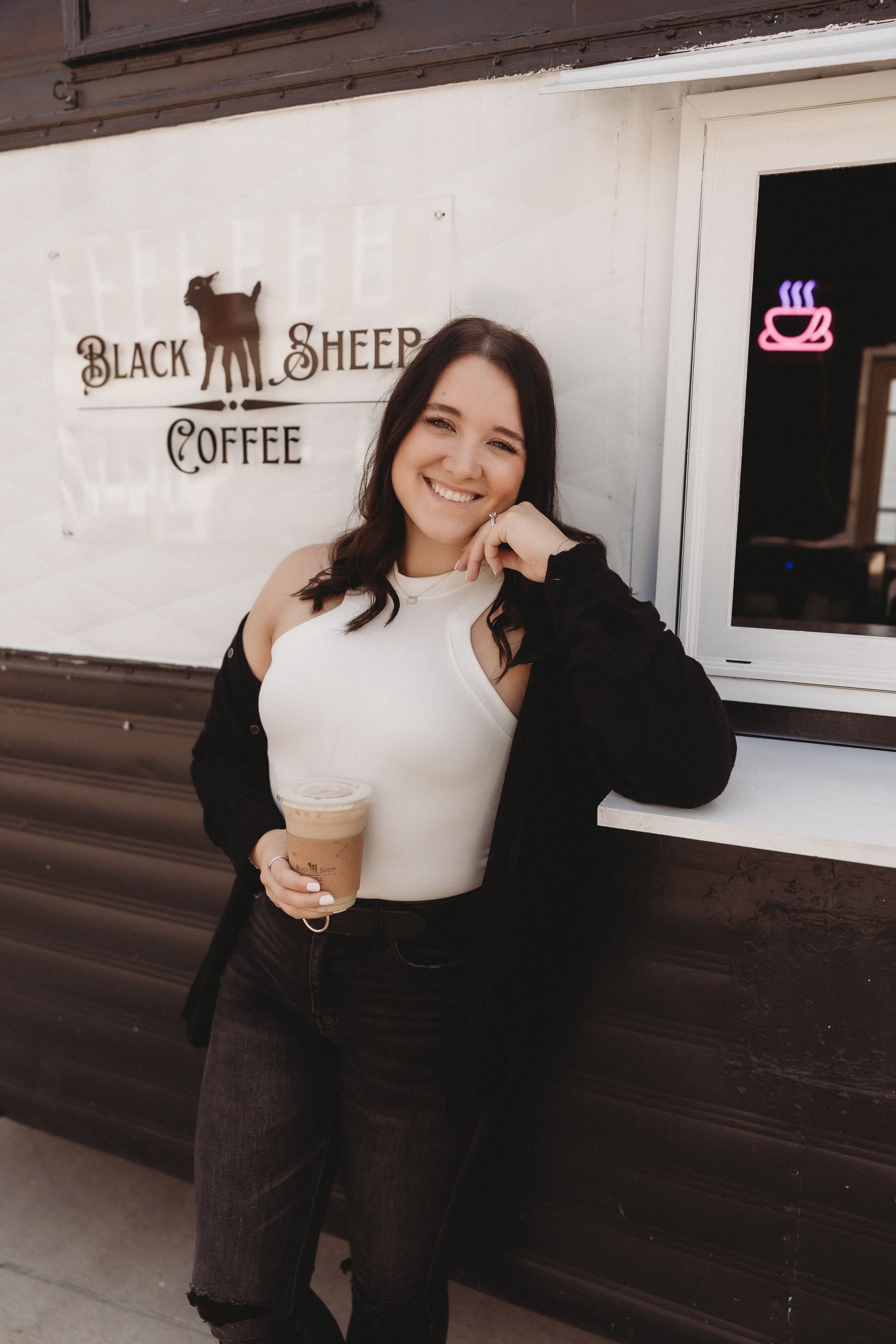  the owner of black sheep coffee smiles and leans against the trailer during their coffee shop photoshoot 