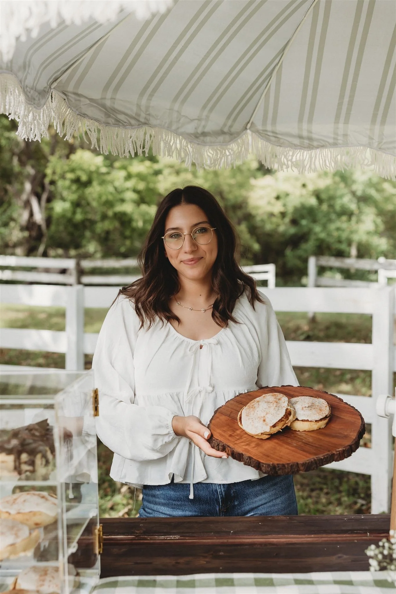 Wild Flour Sourdough Bakehouse owner holding a wood slab with sourdough English muffins at an outdoor market — brand photography, Central Illinois