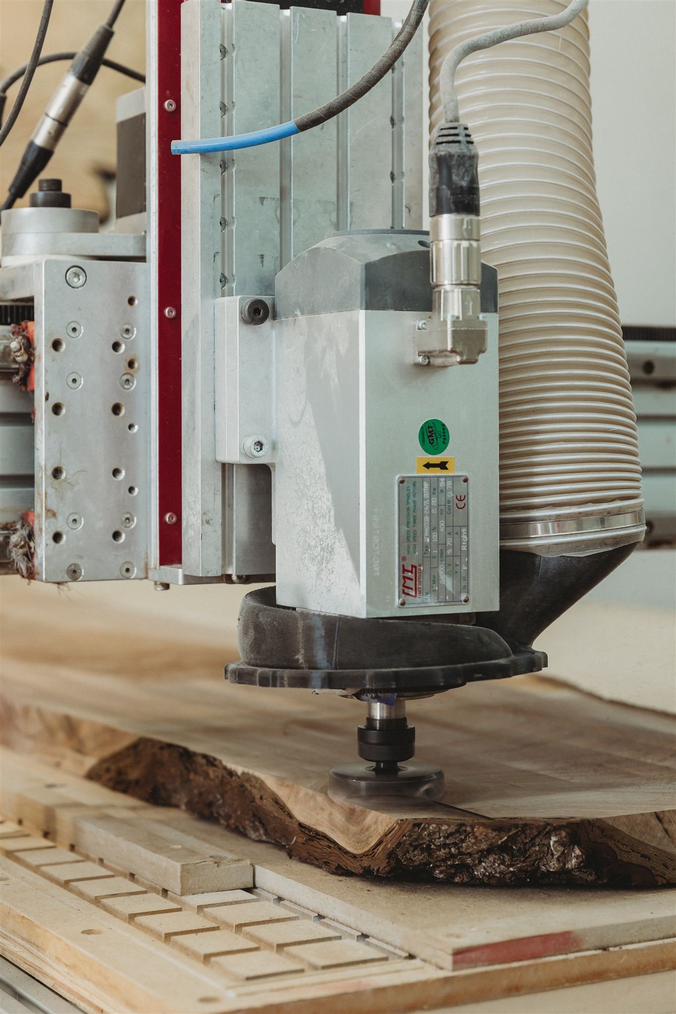 A CNC machine carving a piece of wood on a worktable.