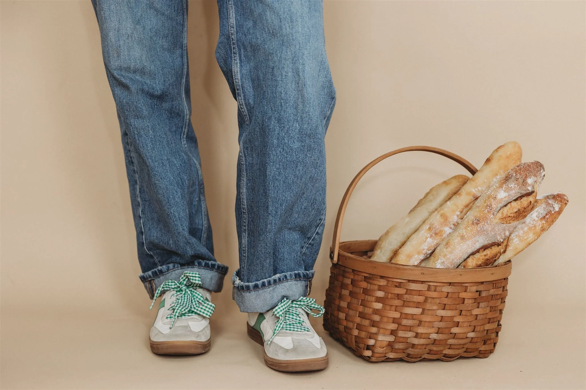 Person standing next to a wicker basket of sourdough baguettes — Wild Flour Sourdough Bakehouse brand photography, Central Illinois