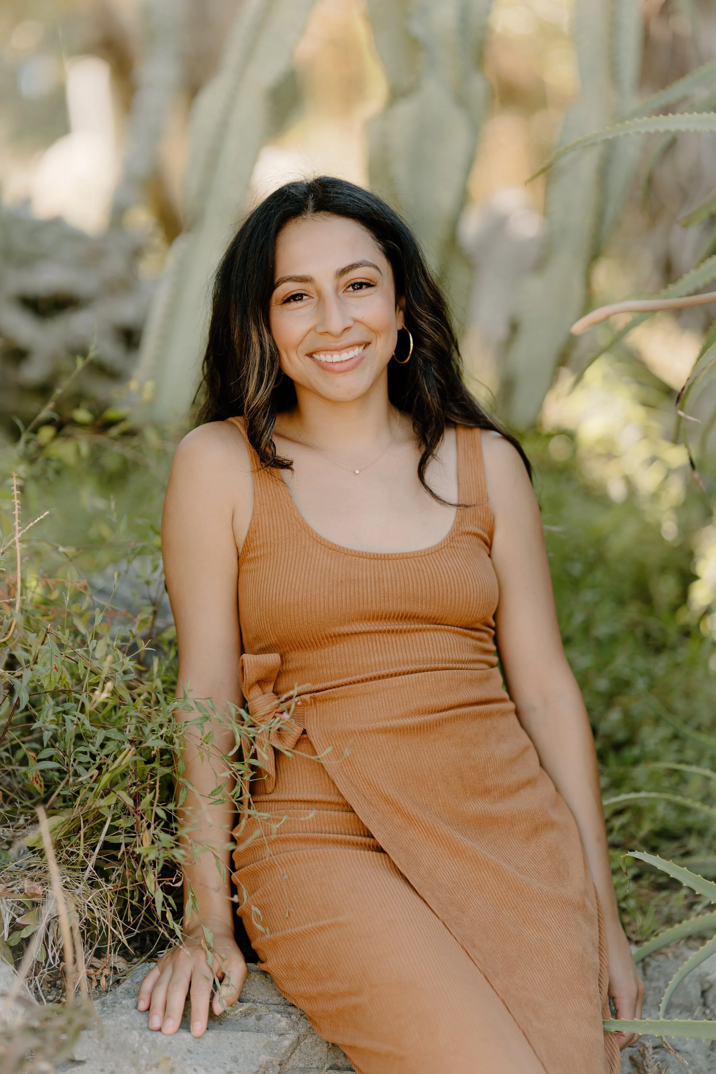 Evelyn Mindful Tanning Sitting against a wall