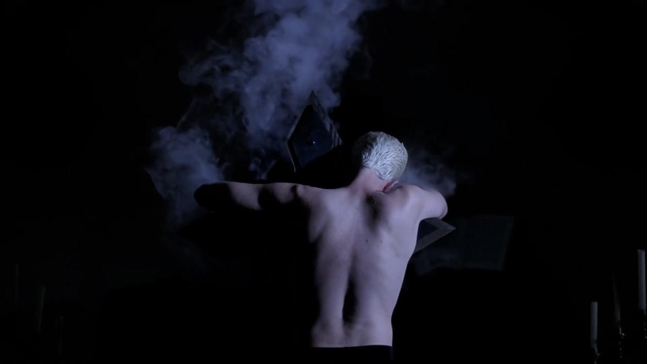 From the movie Alien, a person in a space suit looks down at an egg that is beginning to open.