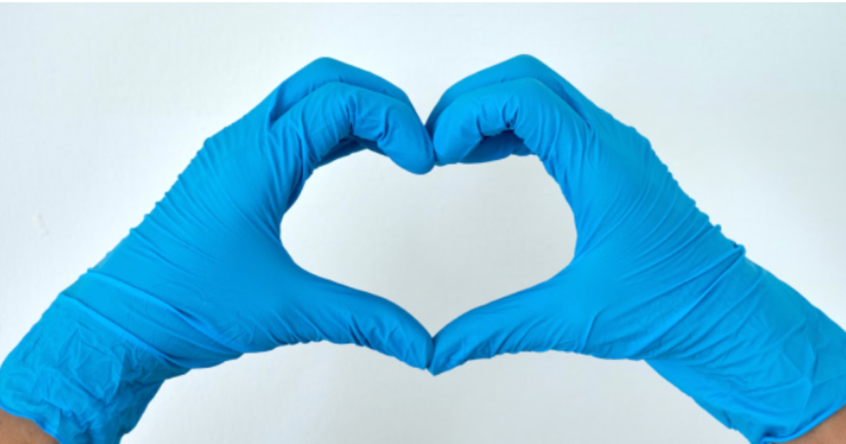 Hands wearing blue gloves forming a heart shape.