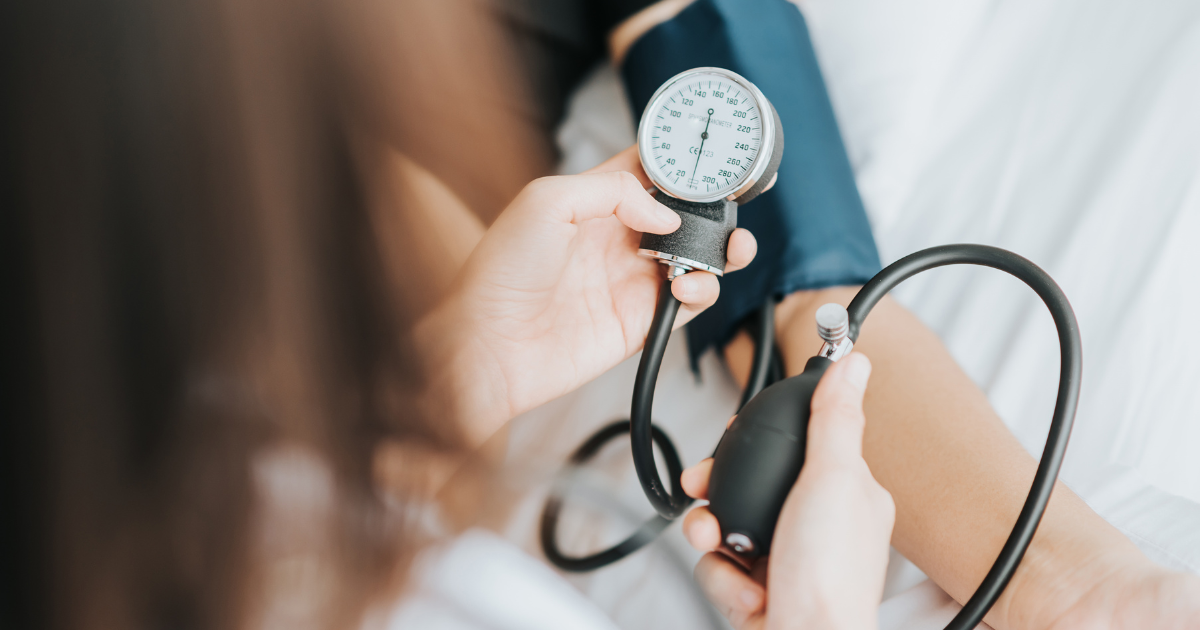 A healthcare professional measuring blood pressure using a sphygmomanometer on a patient's arm.