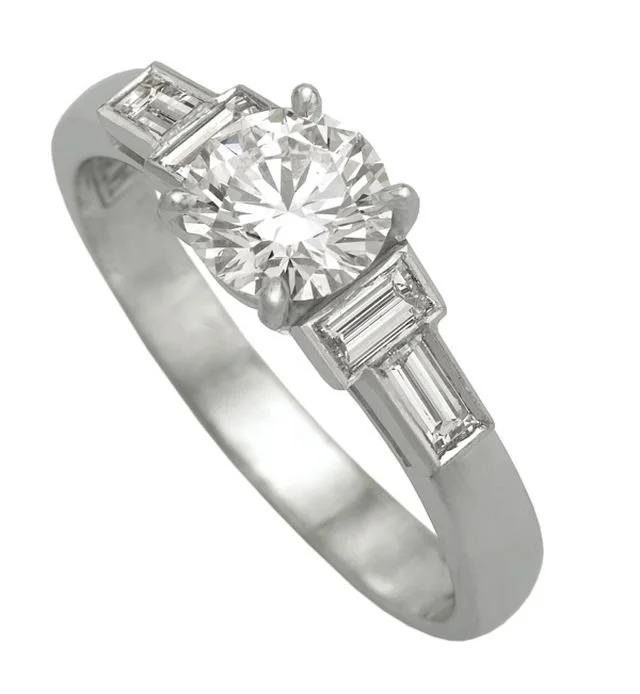 A White gold ring with a large round diamond in the center and two smaller rectangular diamonds on each side.