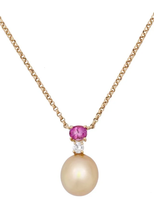 Gold necklace with a large pearl pendant, a pink gemstone, and a small diamond in between.