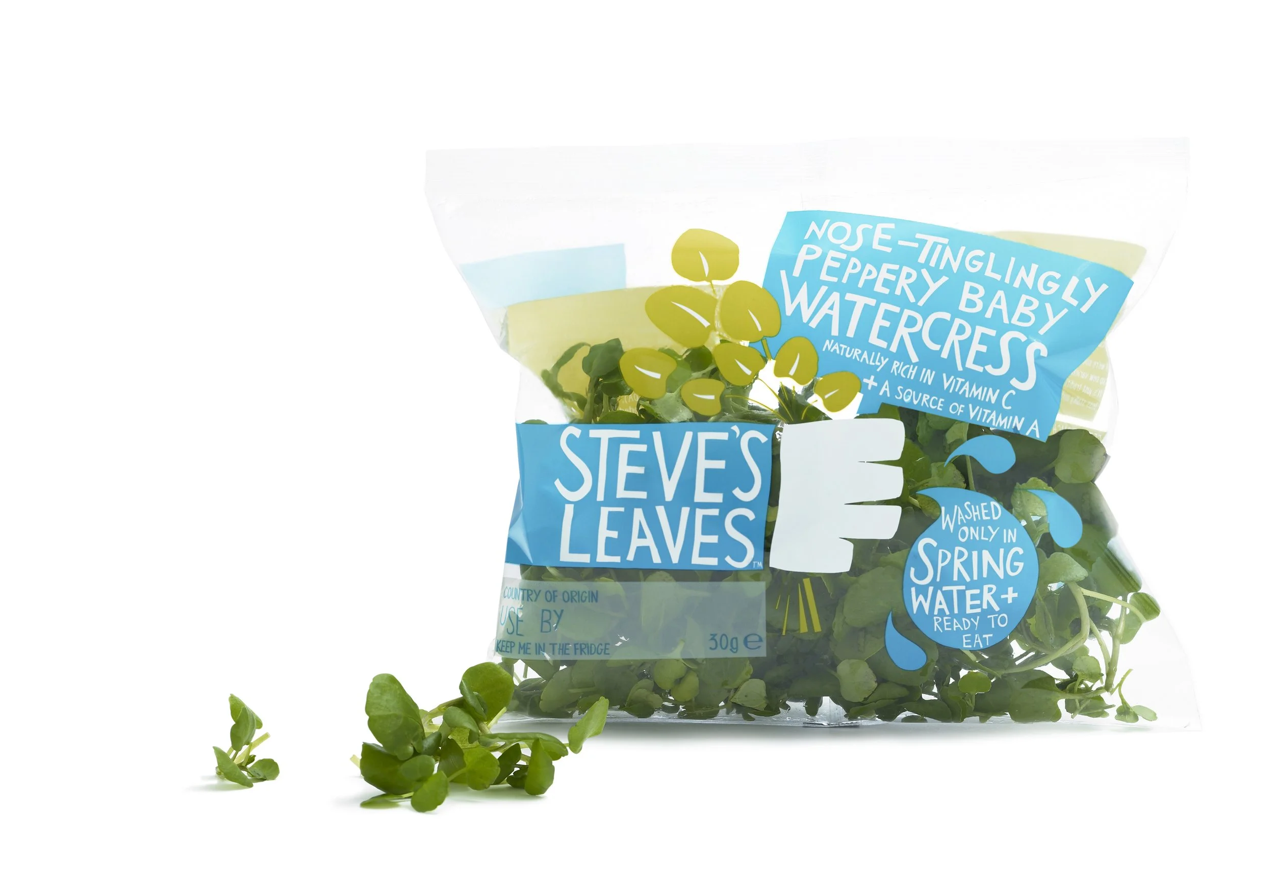 A bag of Steve's Leaves watercress with some watercress leaves spilled in front, colorful packaging highlighting watercress as rich in vitamin C and A, washed in spring water, and ready to eat.