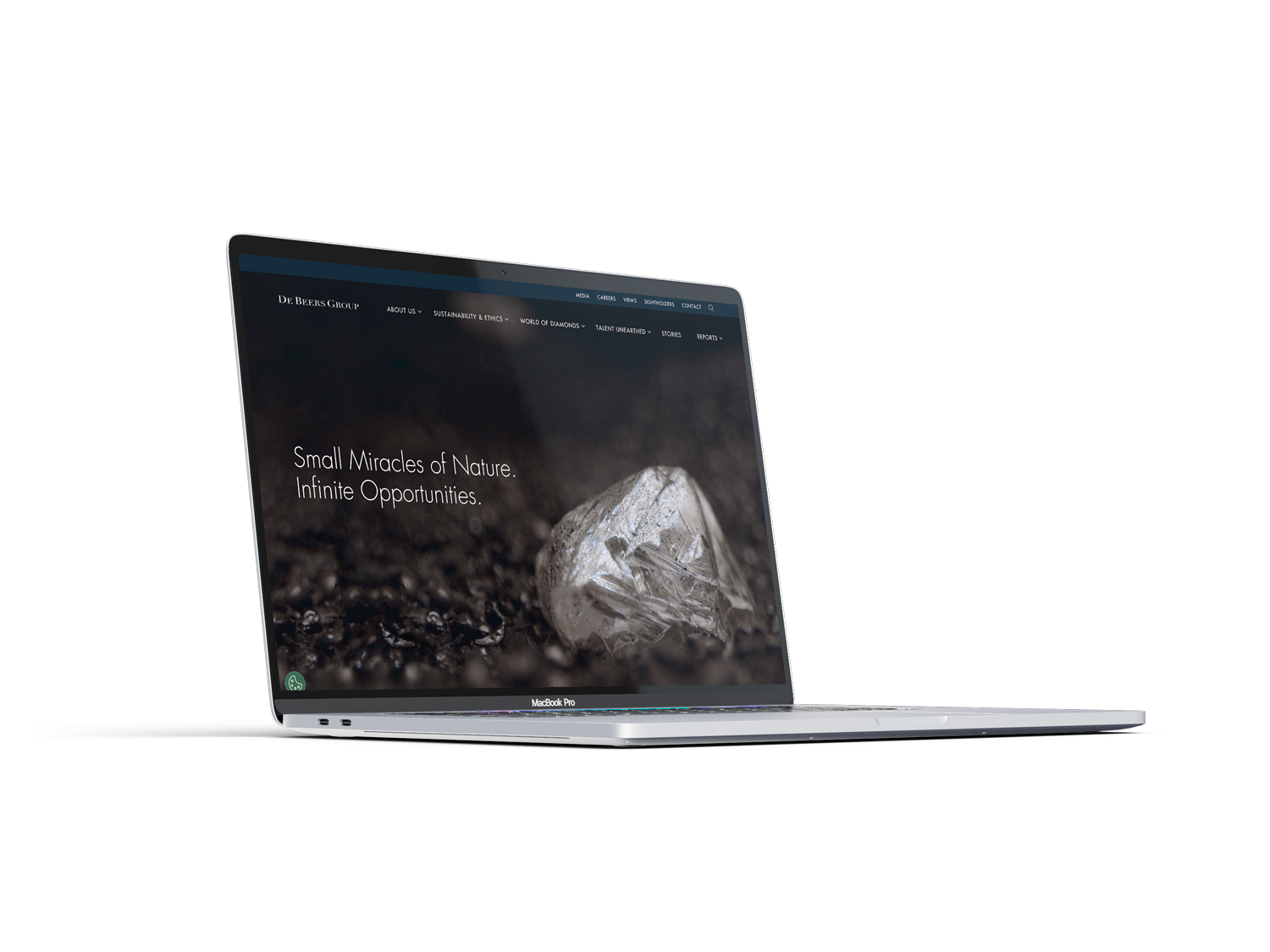 Open MacBook Pro laptop displaying a website with a dark background and an image of a diamond on soil, with text that reads "Small Miracles of Nature. Infinite Opportunities."