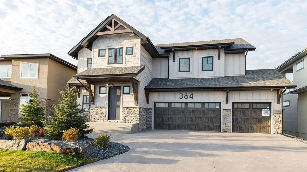 Two-storey home with stone accents, a double garage and landscaped front garden.