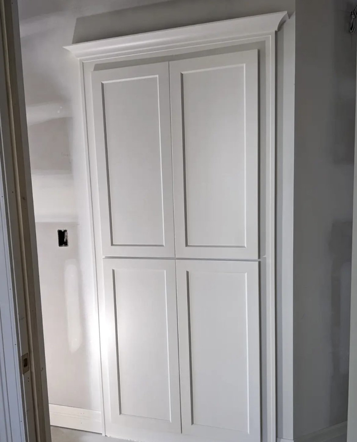 White recessed wall cabinet with paneled doors