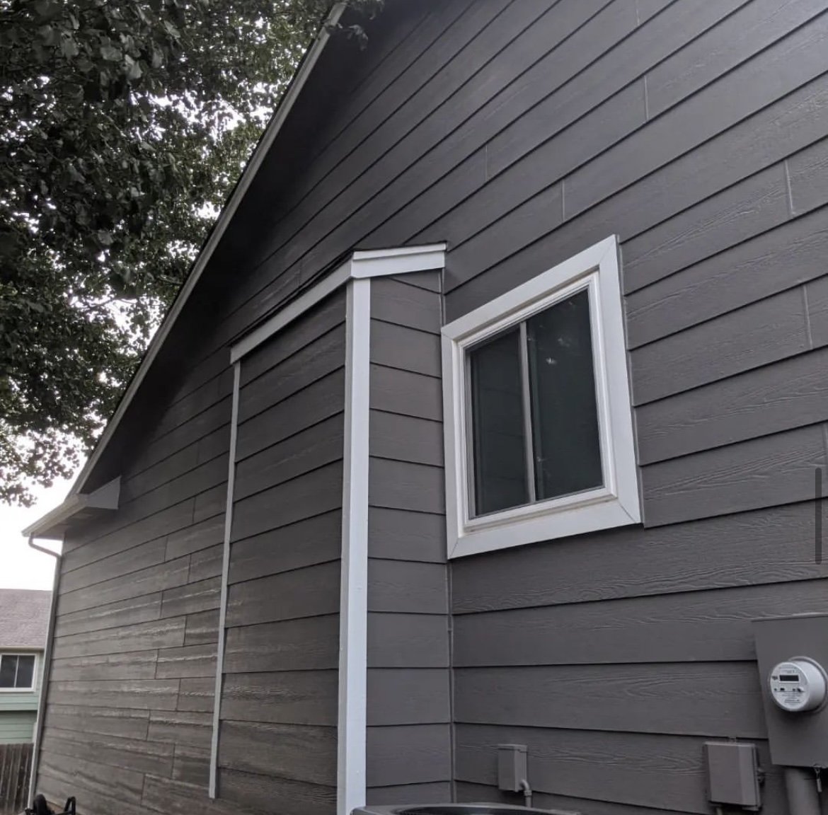 grey house siding with window and electricity meter