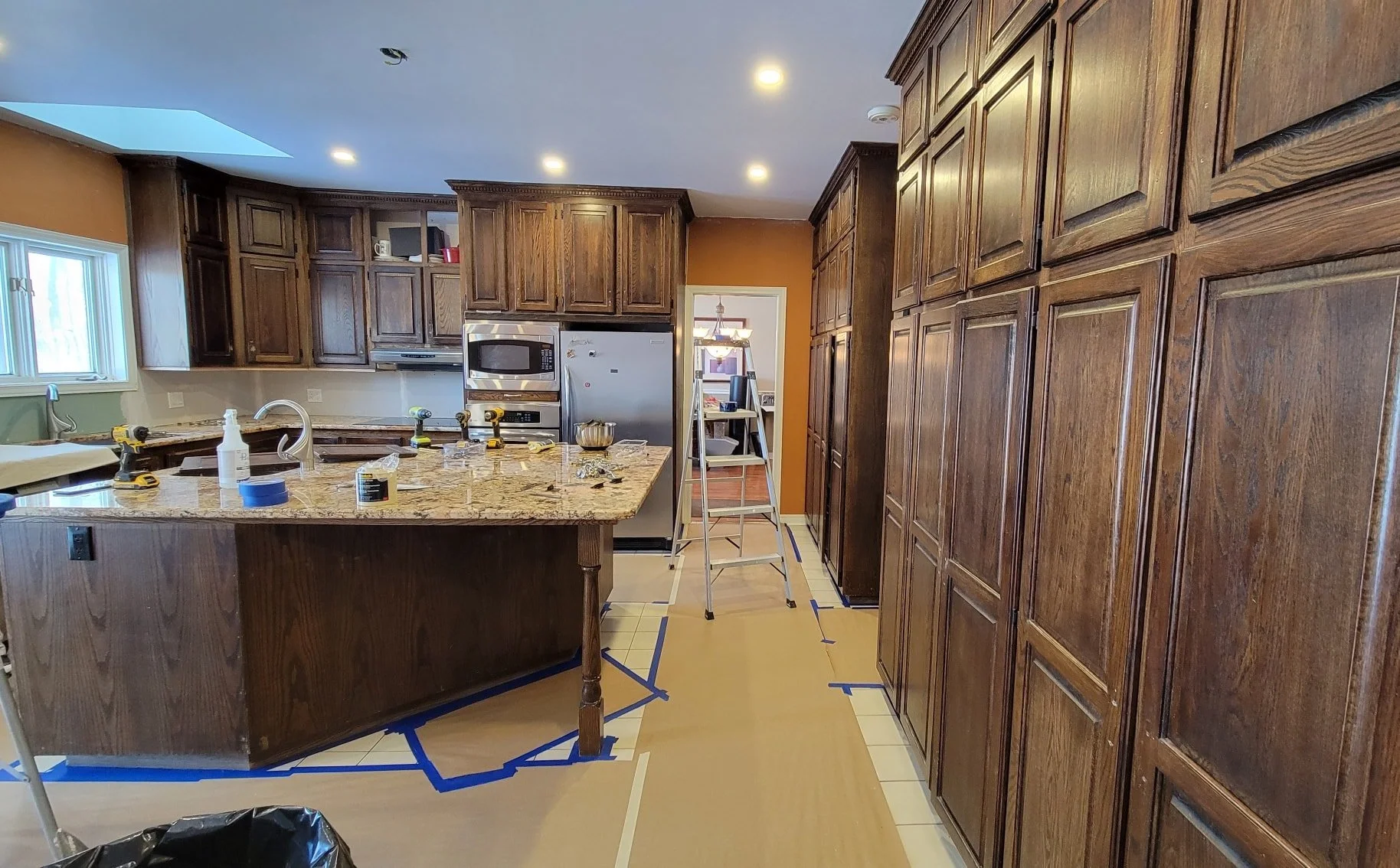 Kitchen with wooden cabinets, granite countertop, and tools for renovation