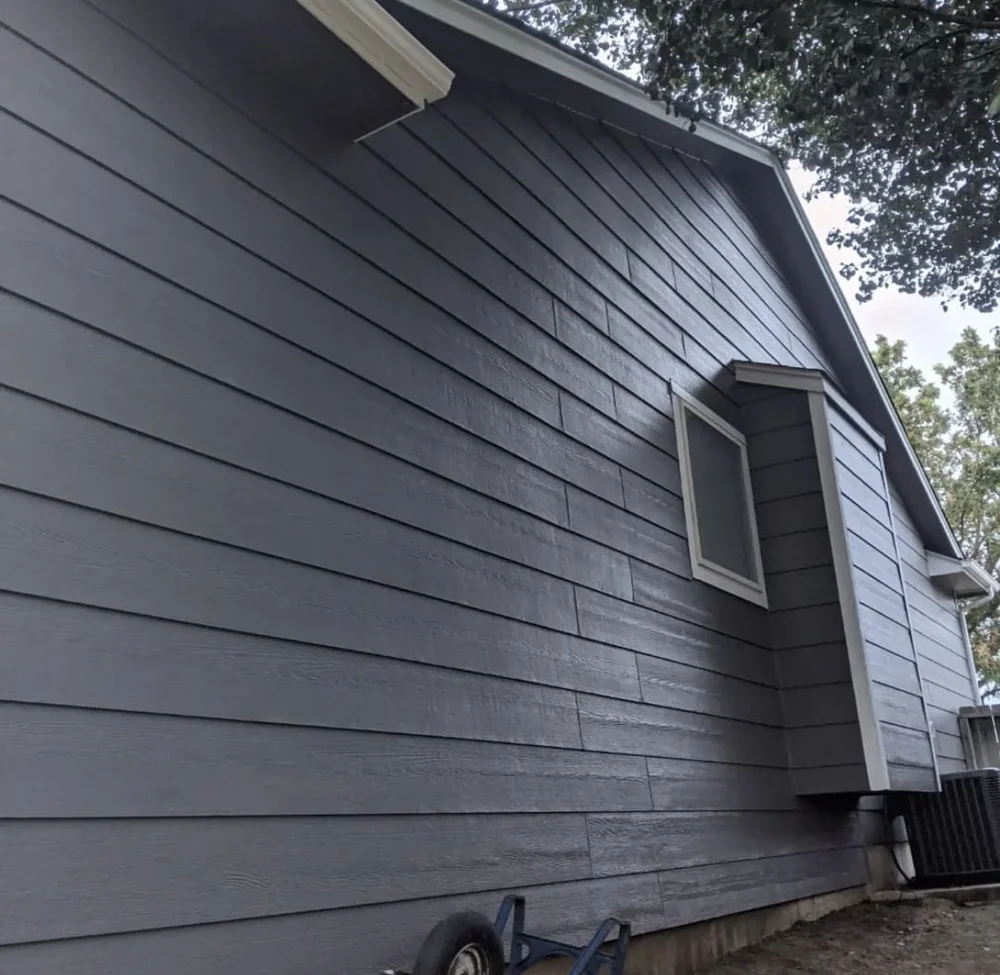 Side elevation of a home with dark grey horizontal siding.