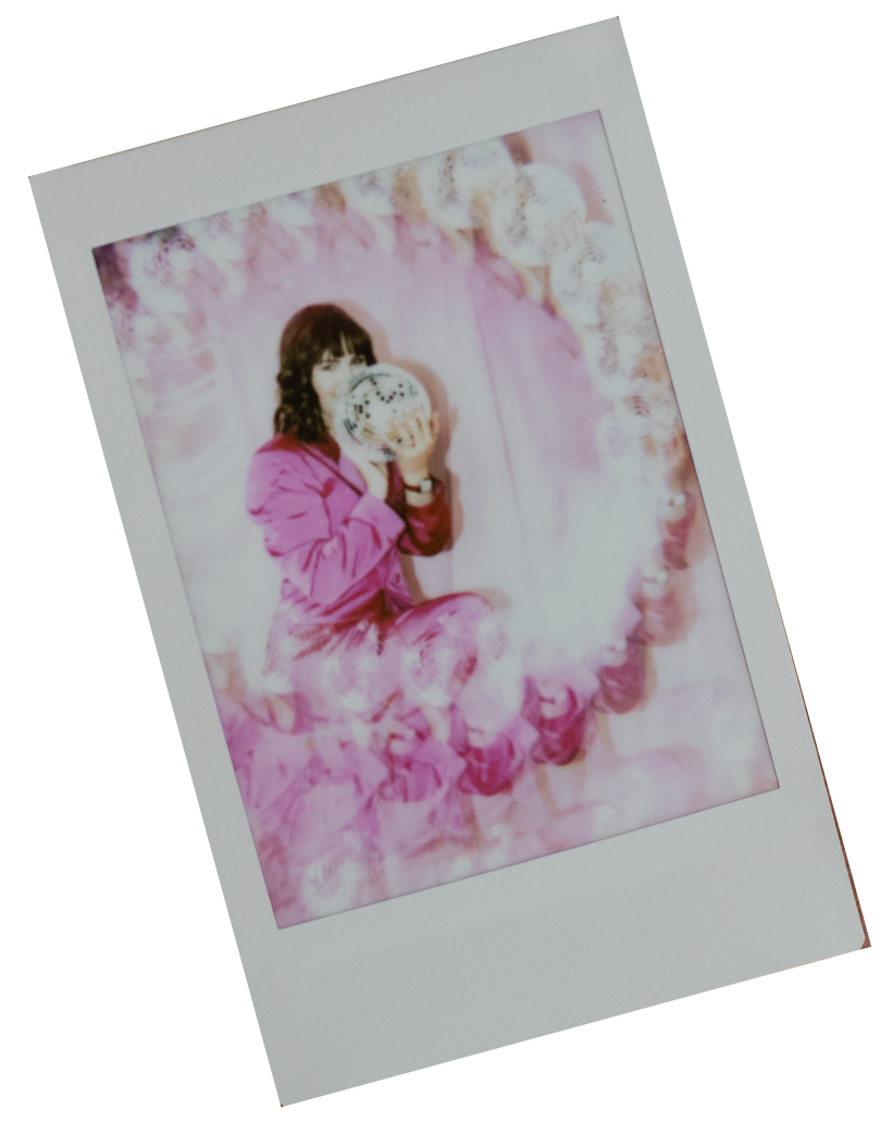 Polaroid of Chloe holding a disco ball, with artsy light leaks.