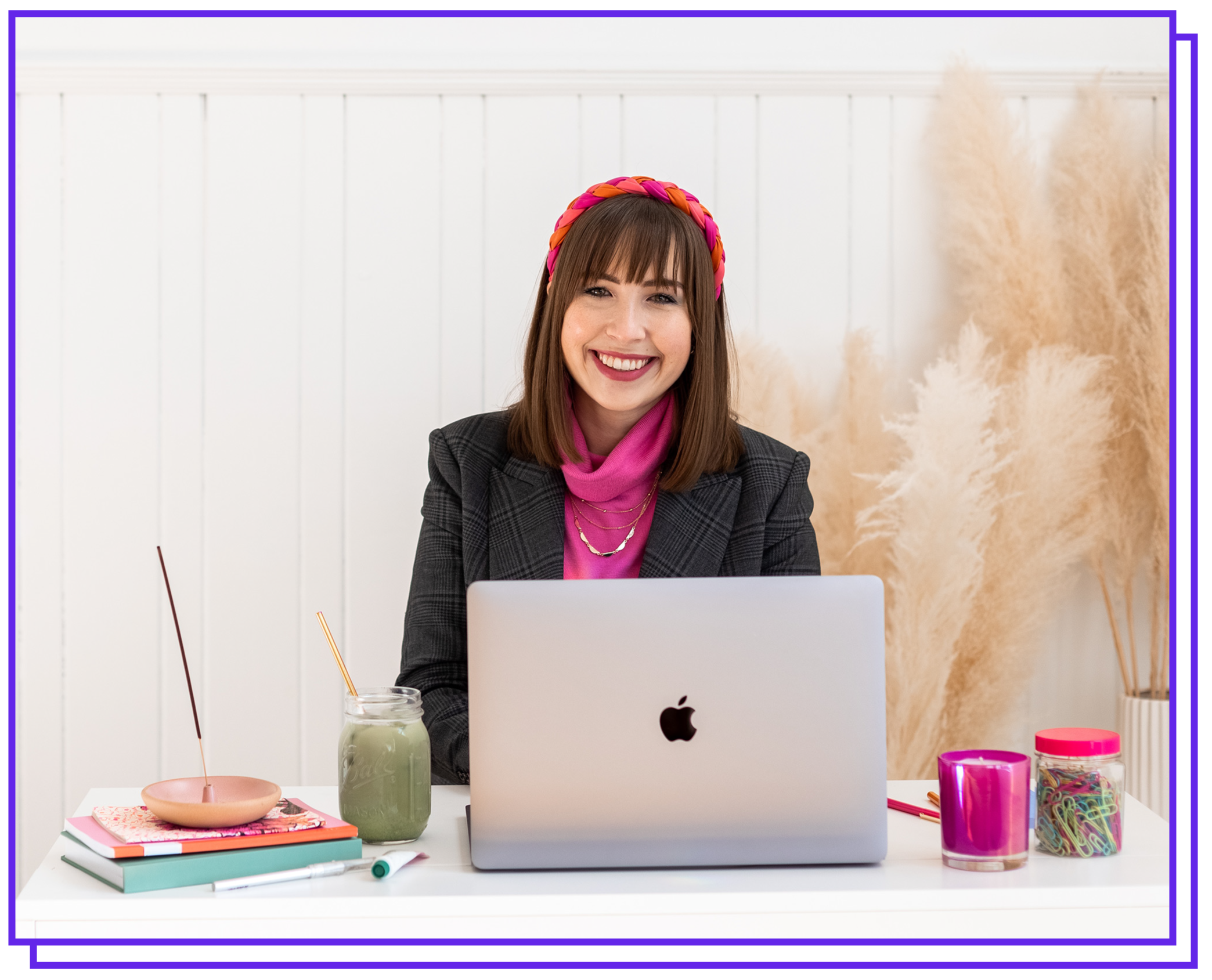 Chloe sitting at a desk working on her computer surrounded by brightly colored office supplies.