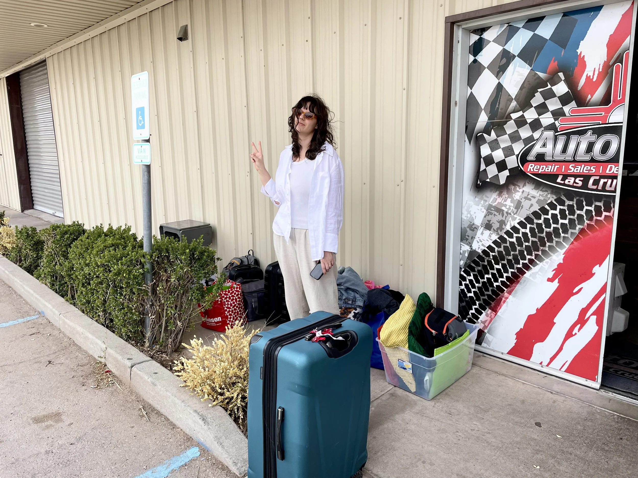 A woman's tanding outside of a mechanic chop in Las Cruces, NM.