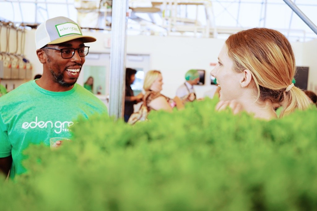 man and woman talking and smiling behind plants at eden green technology.jpg