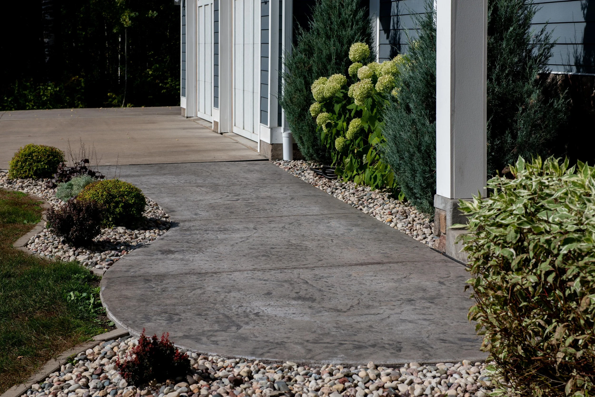 A clean sidewalk with nice landscaping