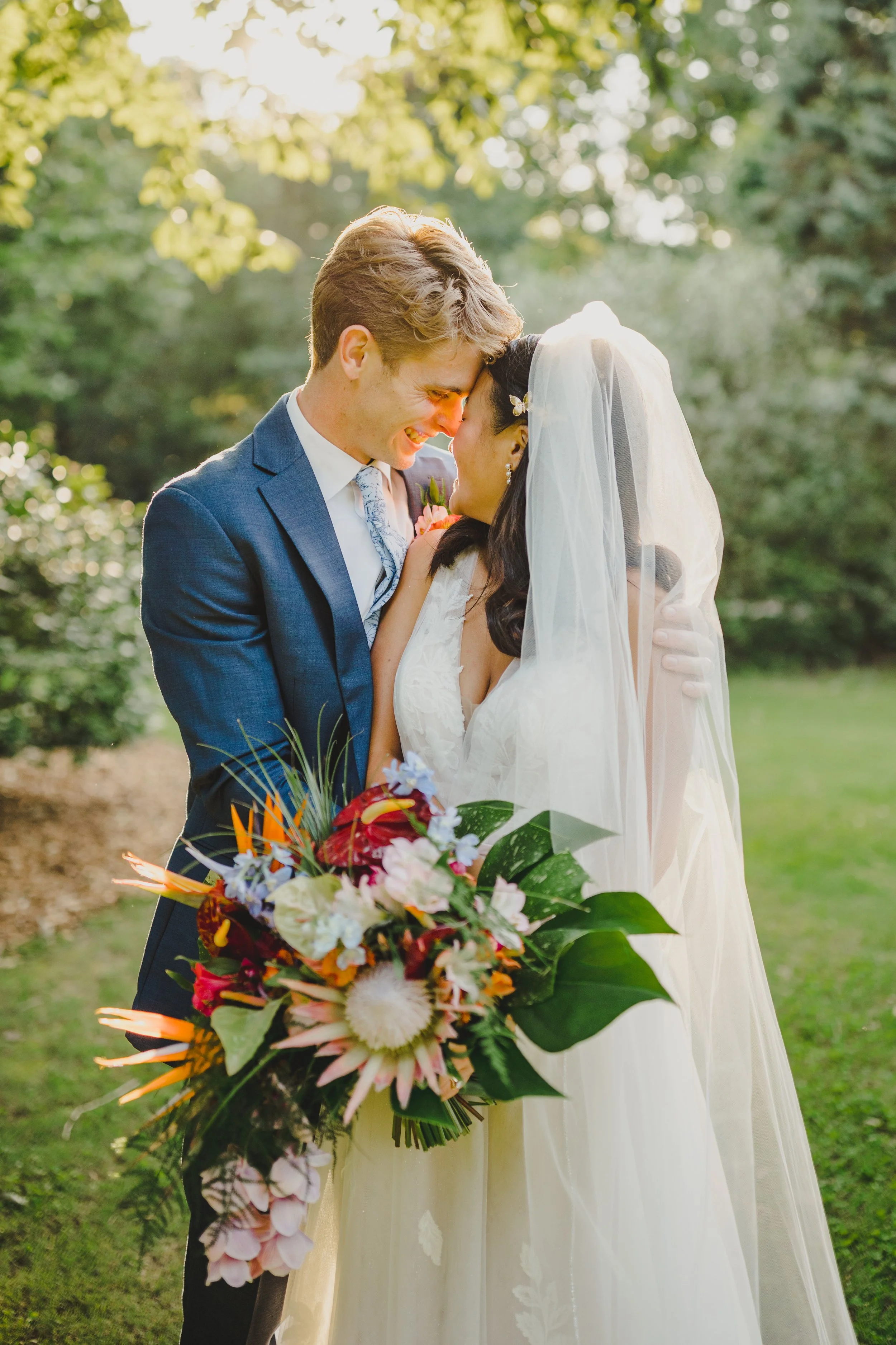 bride and groom with large tropical bridal bouquet