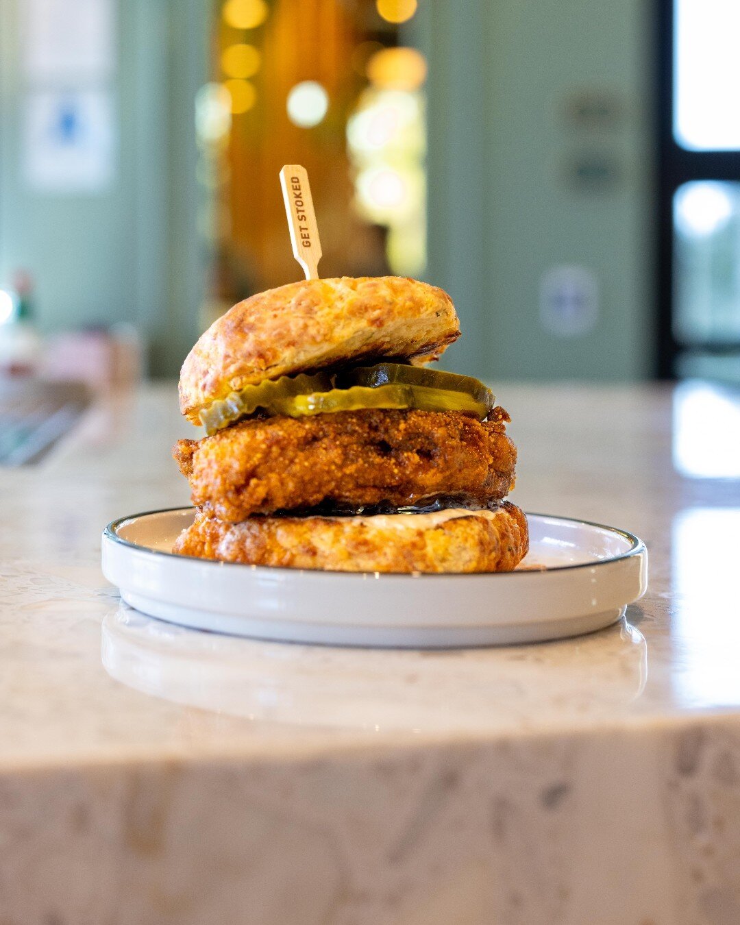This Hot Fried Chicken Sandwich is a must-order when you join us this Mother's Day for our Spring Brunch!  A beautiful piece of spicy fried chicken, pickles, and whipped maple all between a baked in-house cheddar scone 🌶