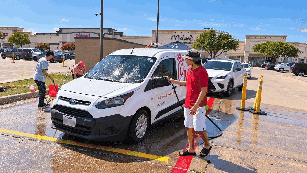 Volunteers wash the Chick-fil-A Park Blvd. & Plano Pkwy. van during the Uganda school fundraiser in Plano.