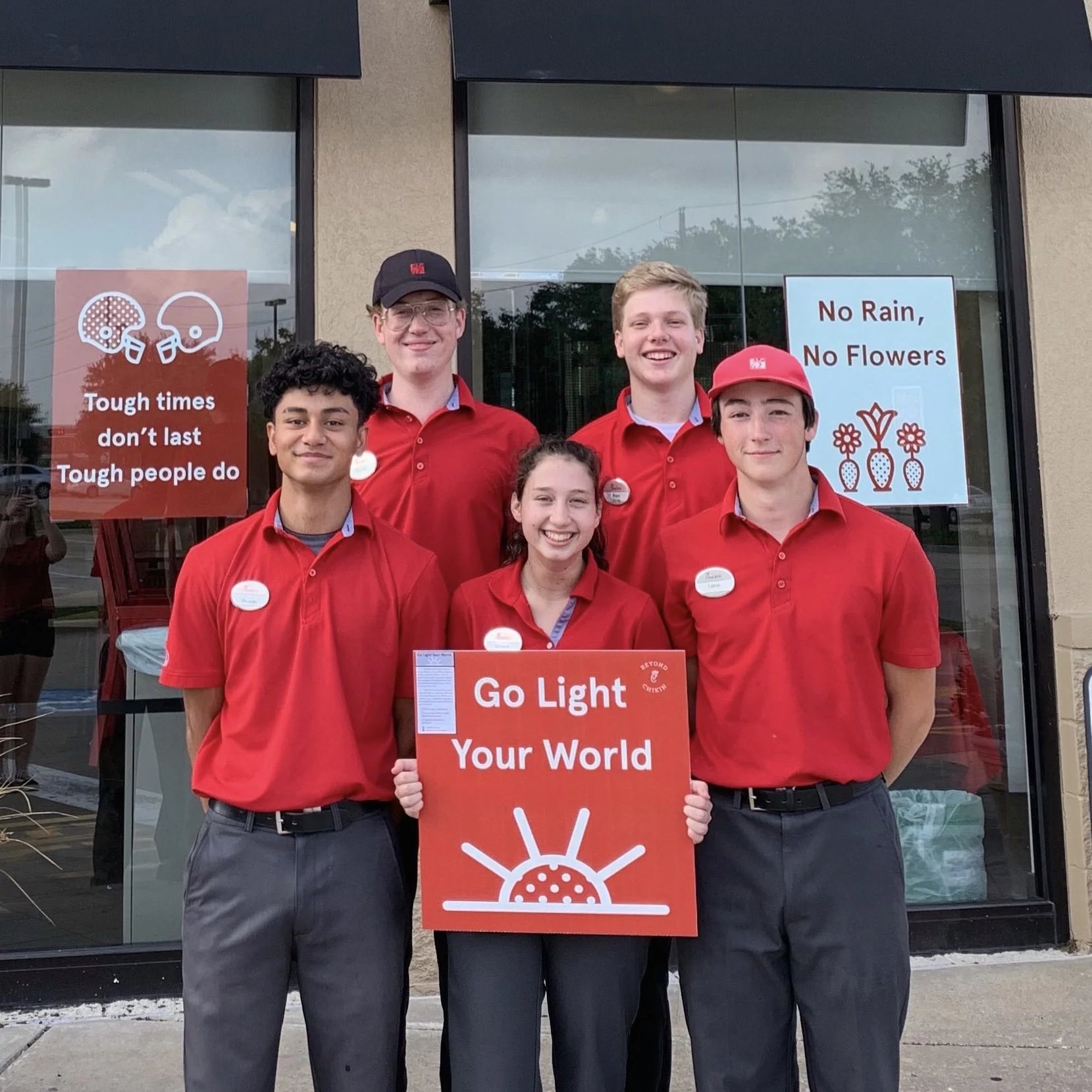 Chick-fil-A team members with restaurant motto 'Go Light Your World.'" to remind them to make a positive difference wherever they go.