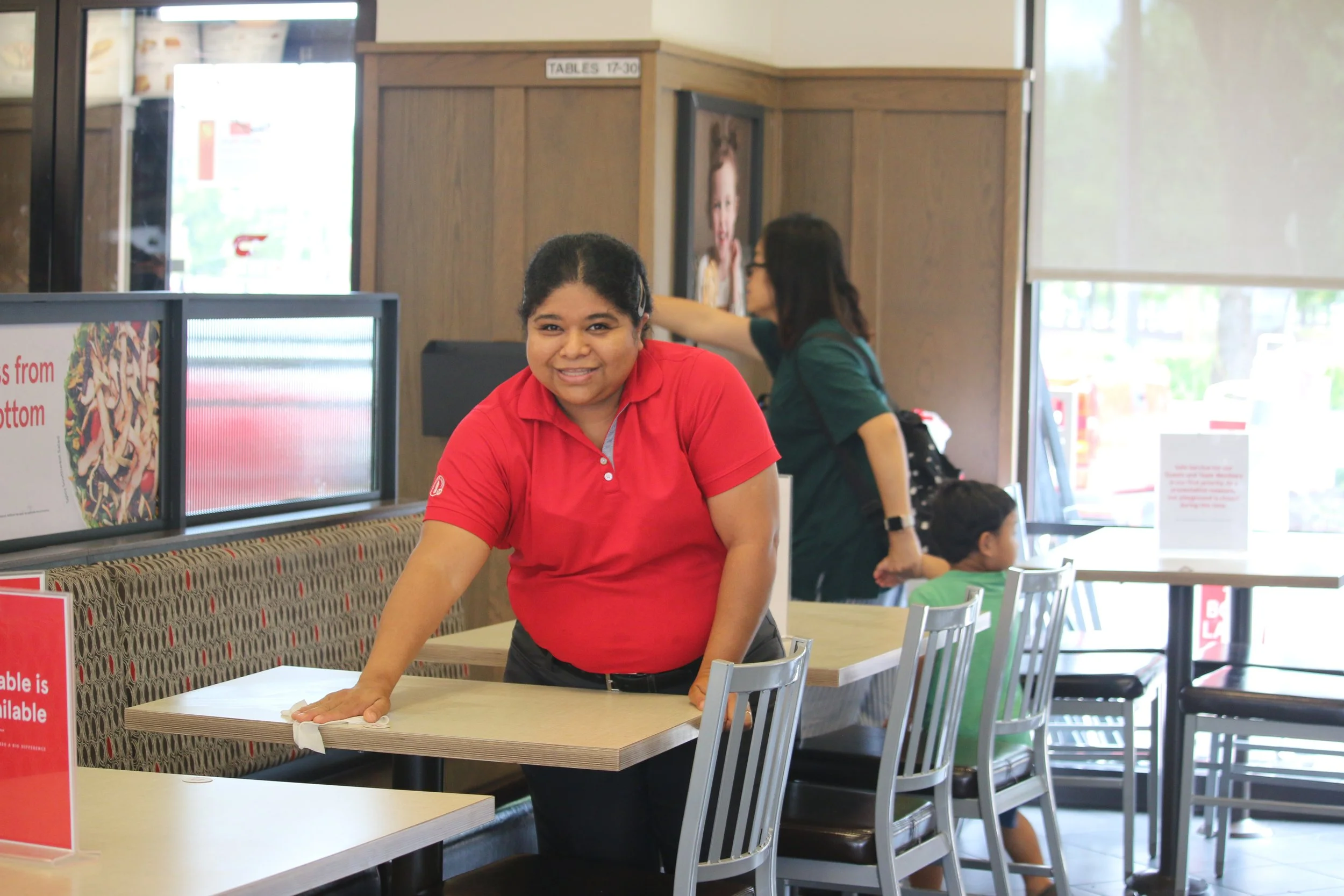 Person cleaning table in fast food restaurant