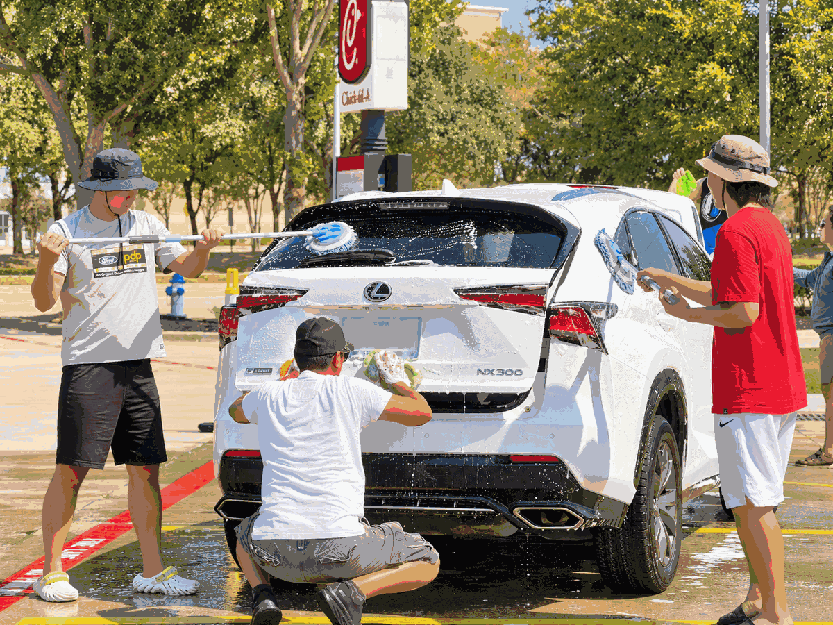 Volunteers scrub a guest’s white SUV at the September 26 car wash fundraiser Chick-fil-A  Park Blvd. & Plano Pkwy.