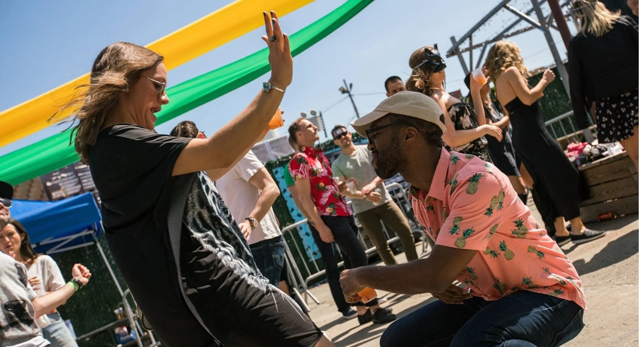 Guests dancing together at an outdoor celebration with curated music and high-energy entertainment by Groove Approved.