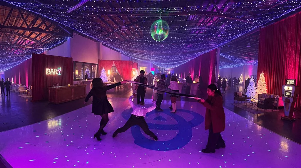 Guests dancing at a Pocket FM holiday party with Groove Approved DJ, lighting, and immersive event entertainment.