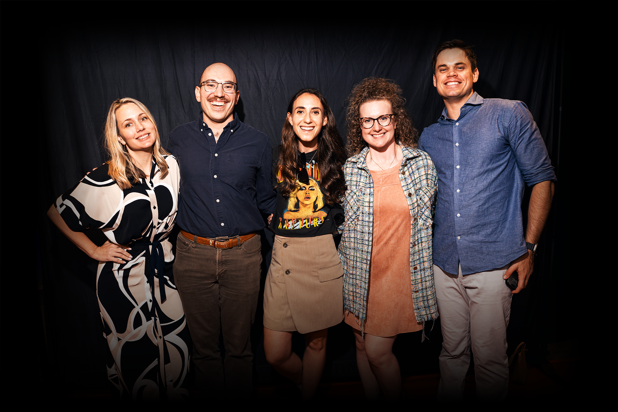 Corporate event guests posing together in front of a black backdrop during a Disco Tech branded company celebration in Los Angeles.