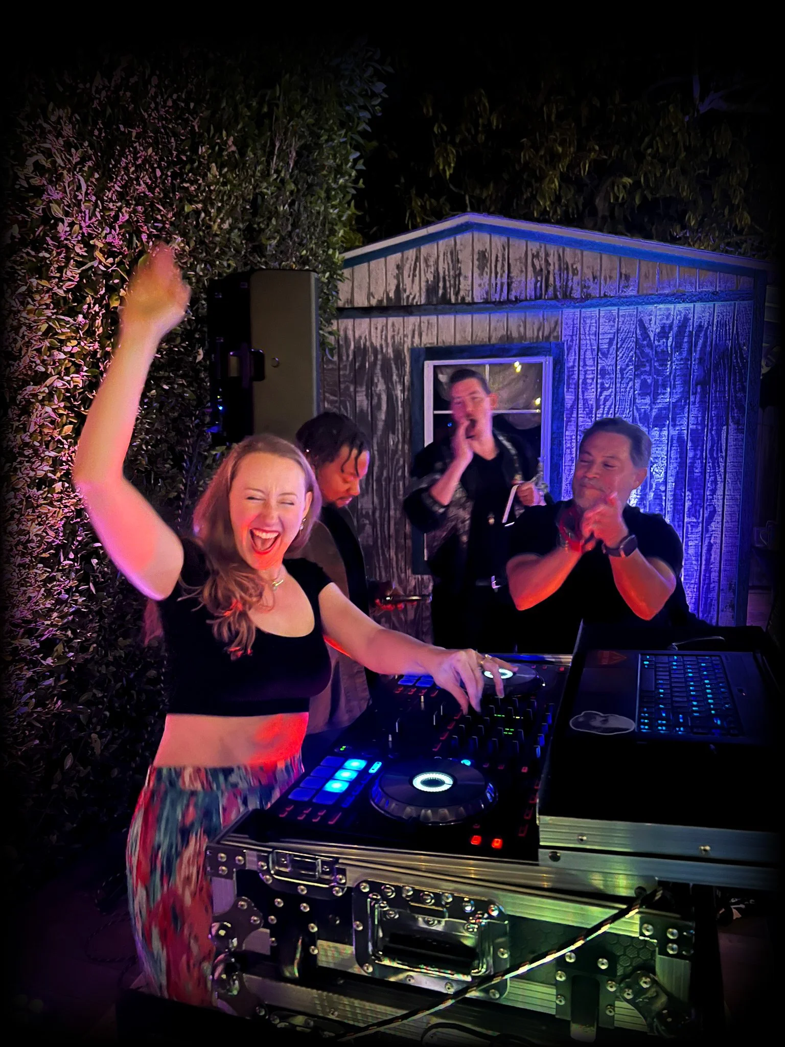 Guests dancing at a backyard bachata party with DJ Matty from Groove Approved providing music and entertainment.