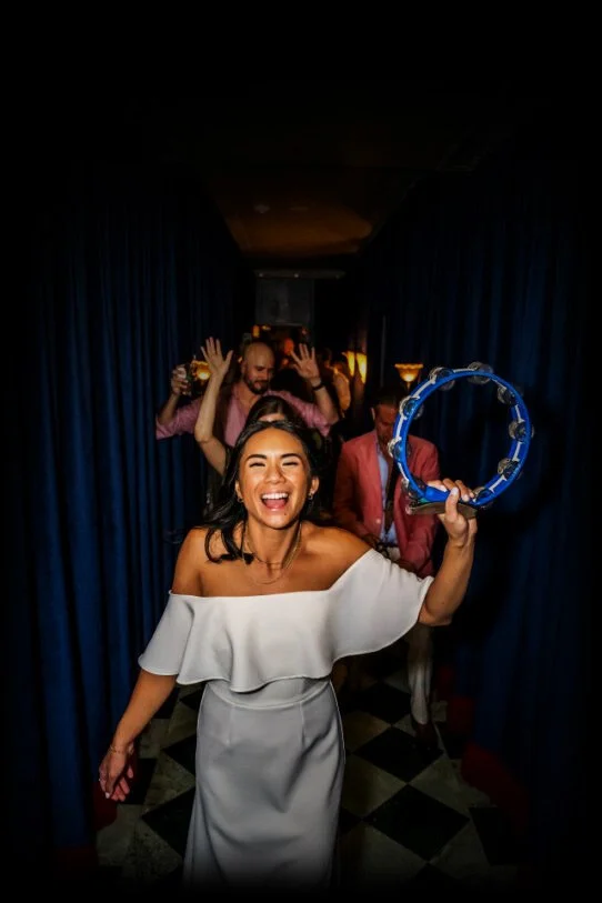 Bride dancing with a tambourine during a Disco Tech Events wedding reception at Lou Lou's Jungle Room in San Diego, CA.