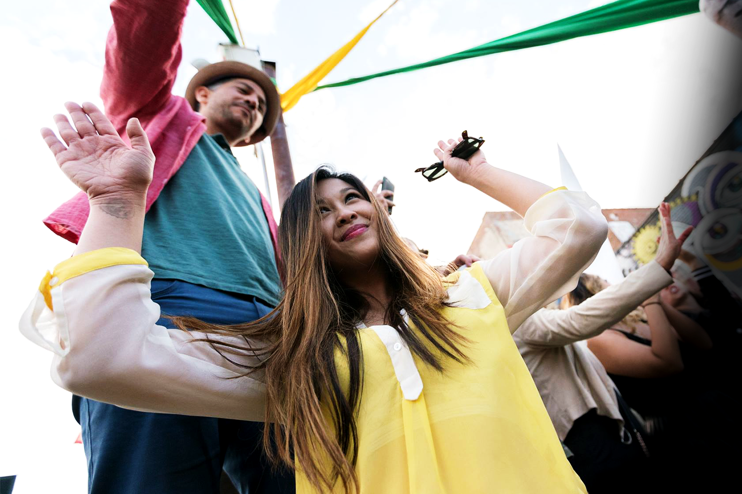 Guests dancing and smiling together during a colorful outdoor Disco Tech day party experience.
