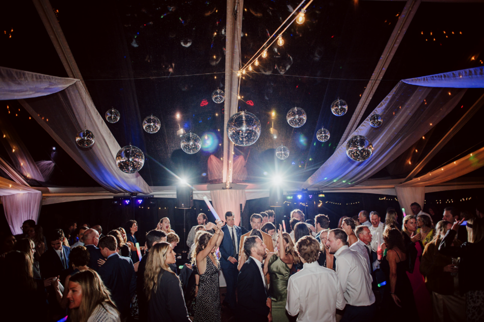 Packed wedding dance floor with professional DJ lighting by Groove Approved at Southern California wedding reception