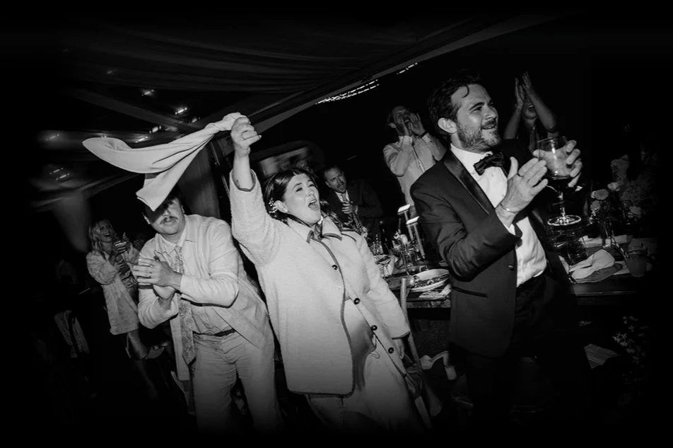 People celebrating at a wedding reception, dancing and enjoying drinks.