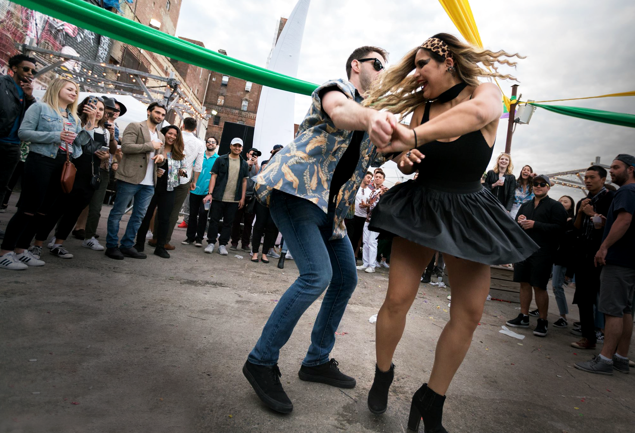 Guests dancing together at a lively outdoor Disco Tech event with music, movement, and crowd interaction.
