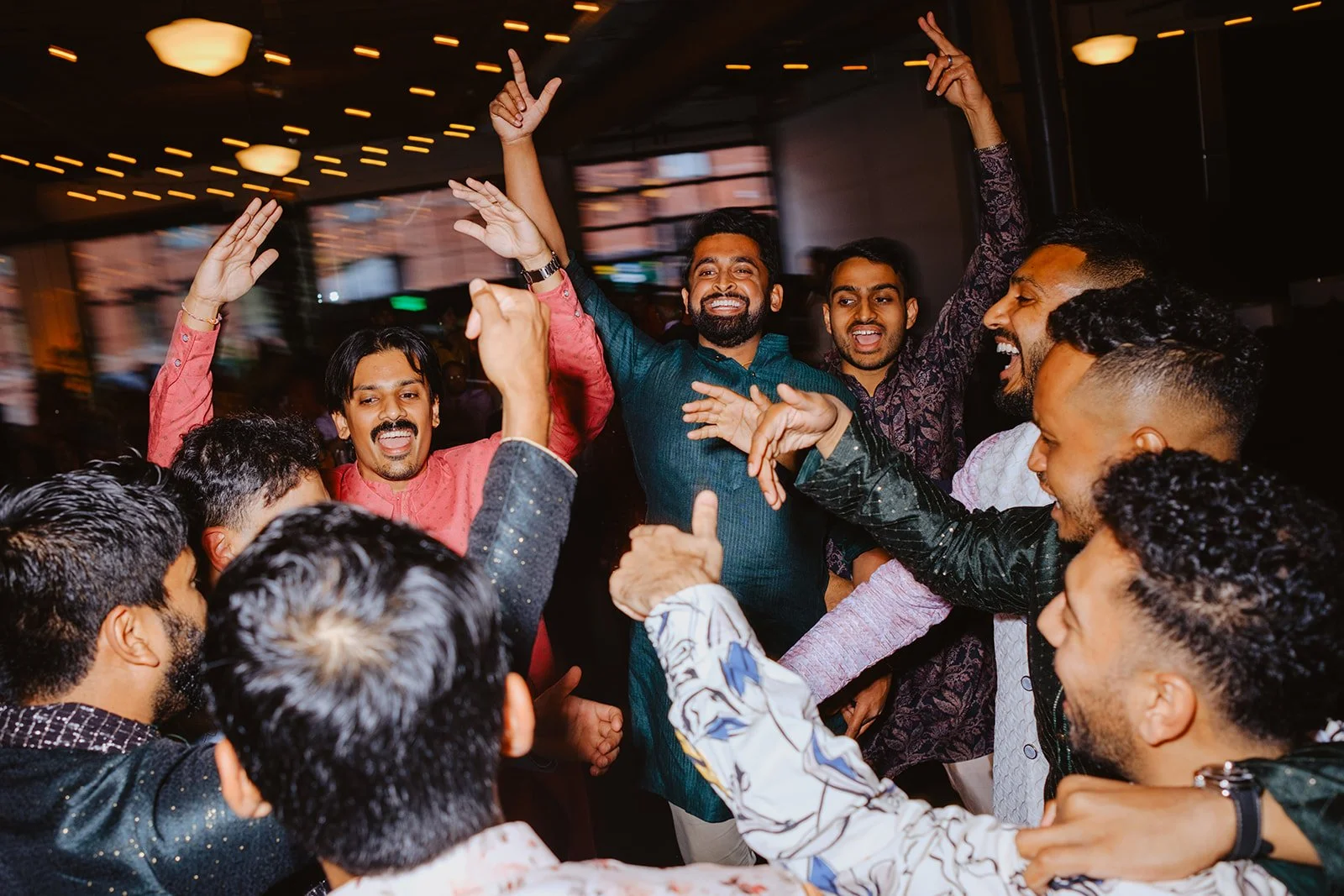 Group of people celebrating and dancing together at a party with joyful expressions.