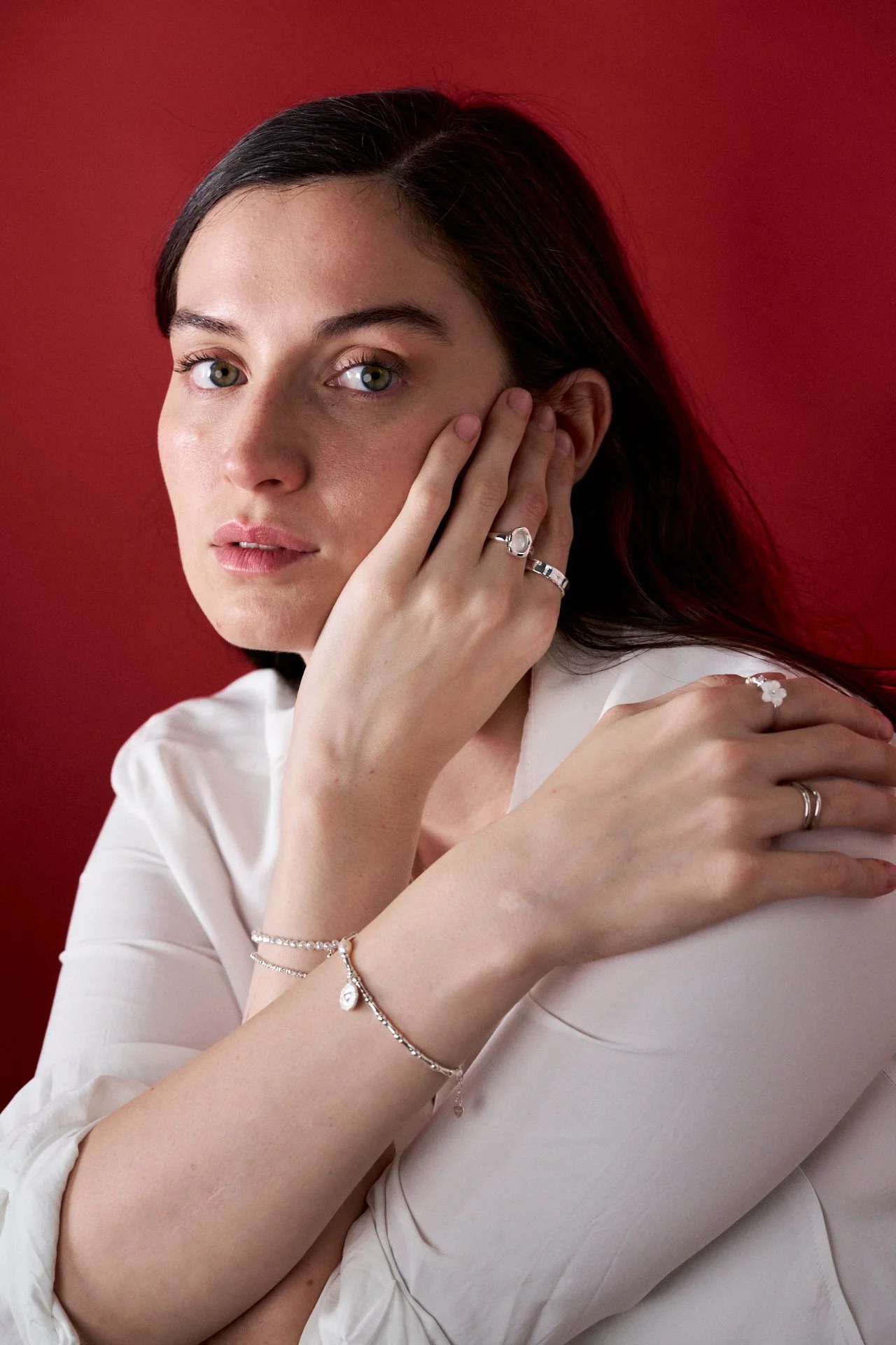 mujer modelando joyas, fotografia editorial, iluminación tenue, joyas de plata, joyas de oro