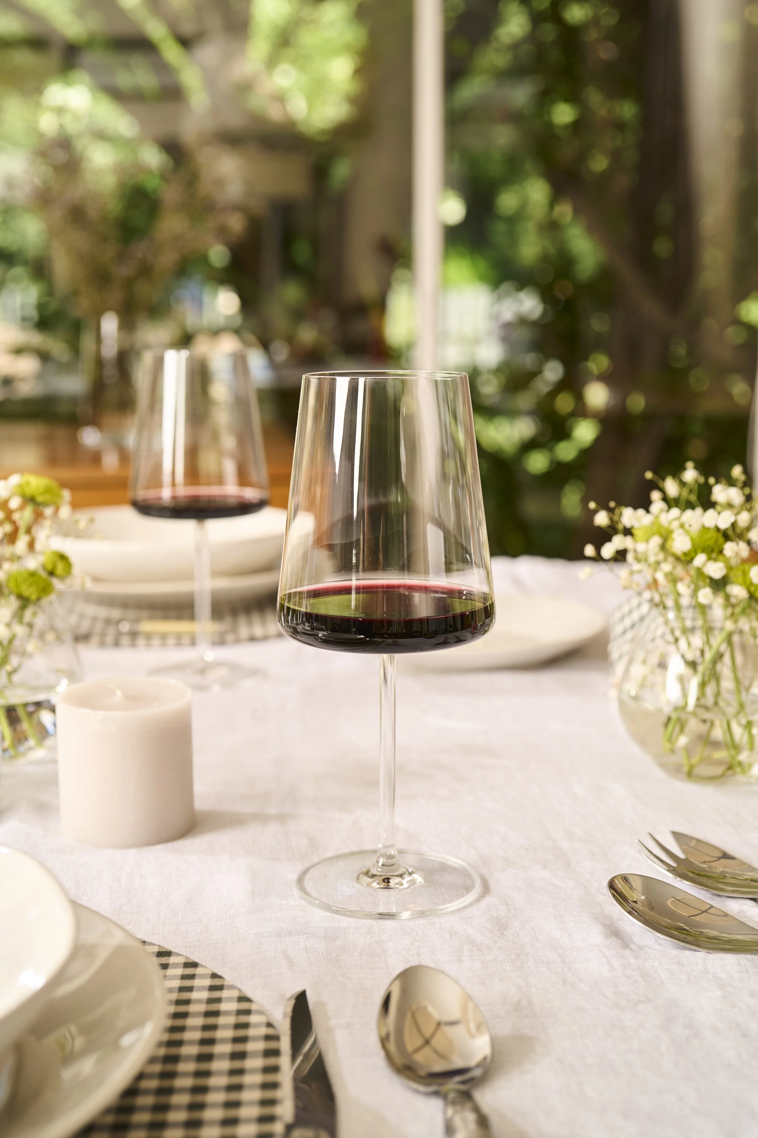 Fotografía publicitaria de menaje de lujo y botellas de vino en ambiente interior.