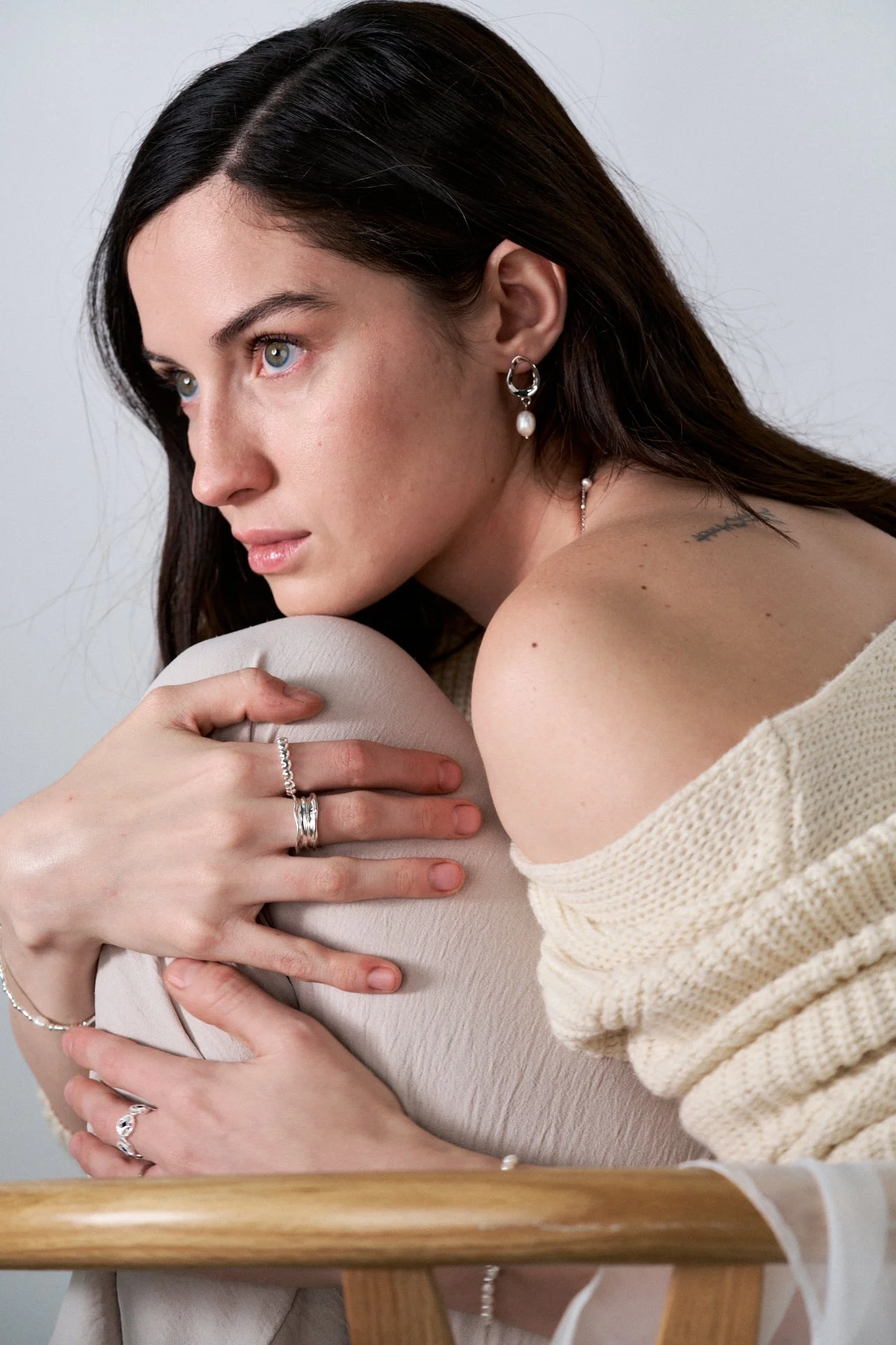 mujer modelando joyas, fotografia editorial, iluminación tenue, joyas de plata, joyas de oro