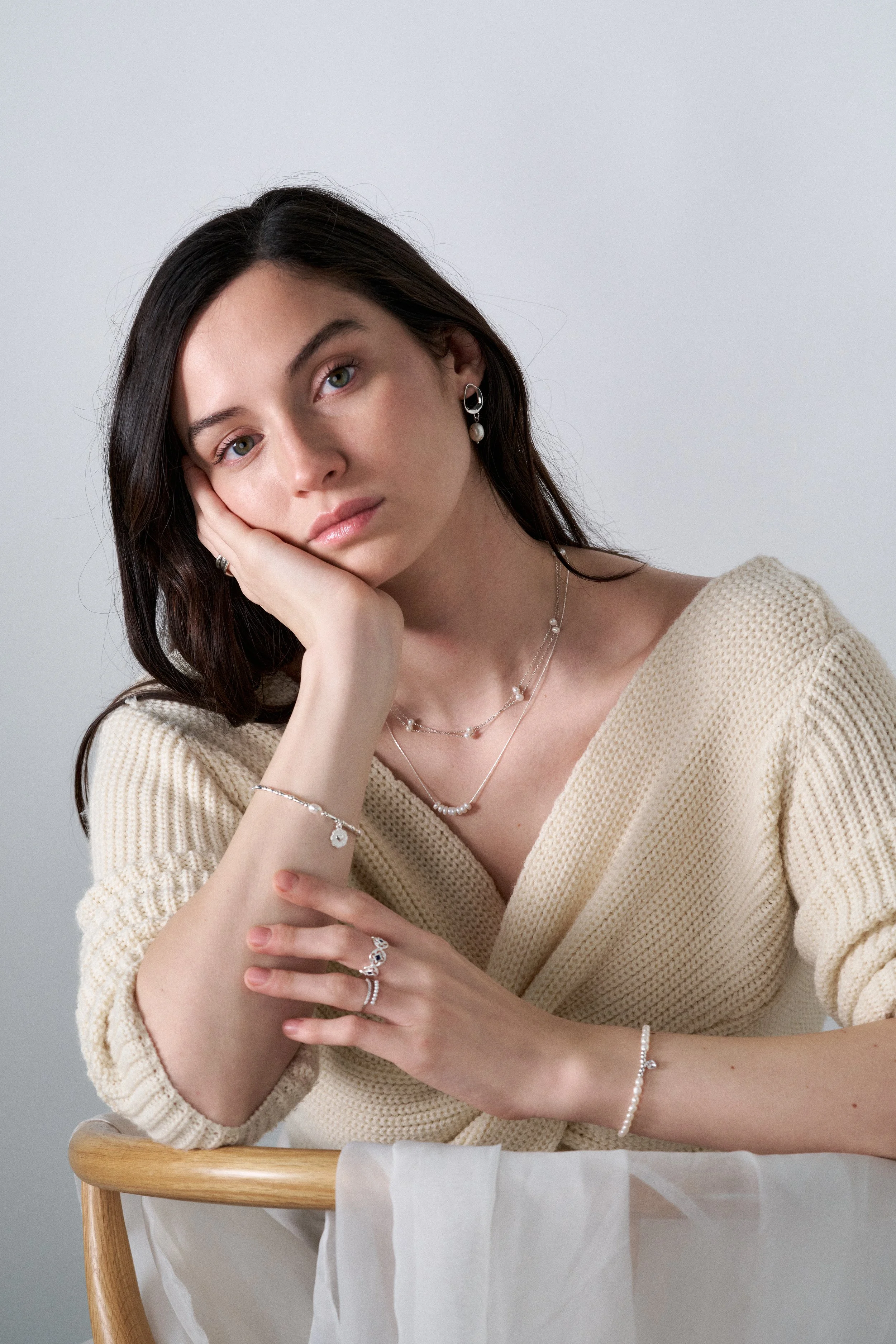 mujer modelando joyas, fotografia editorial, iluminación tenue, joyas de plata, joyas de oro