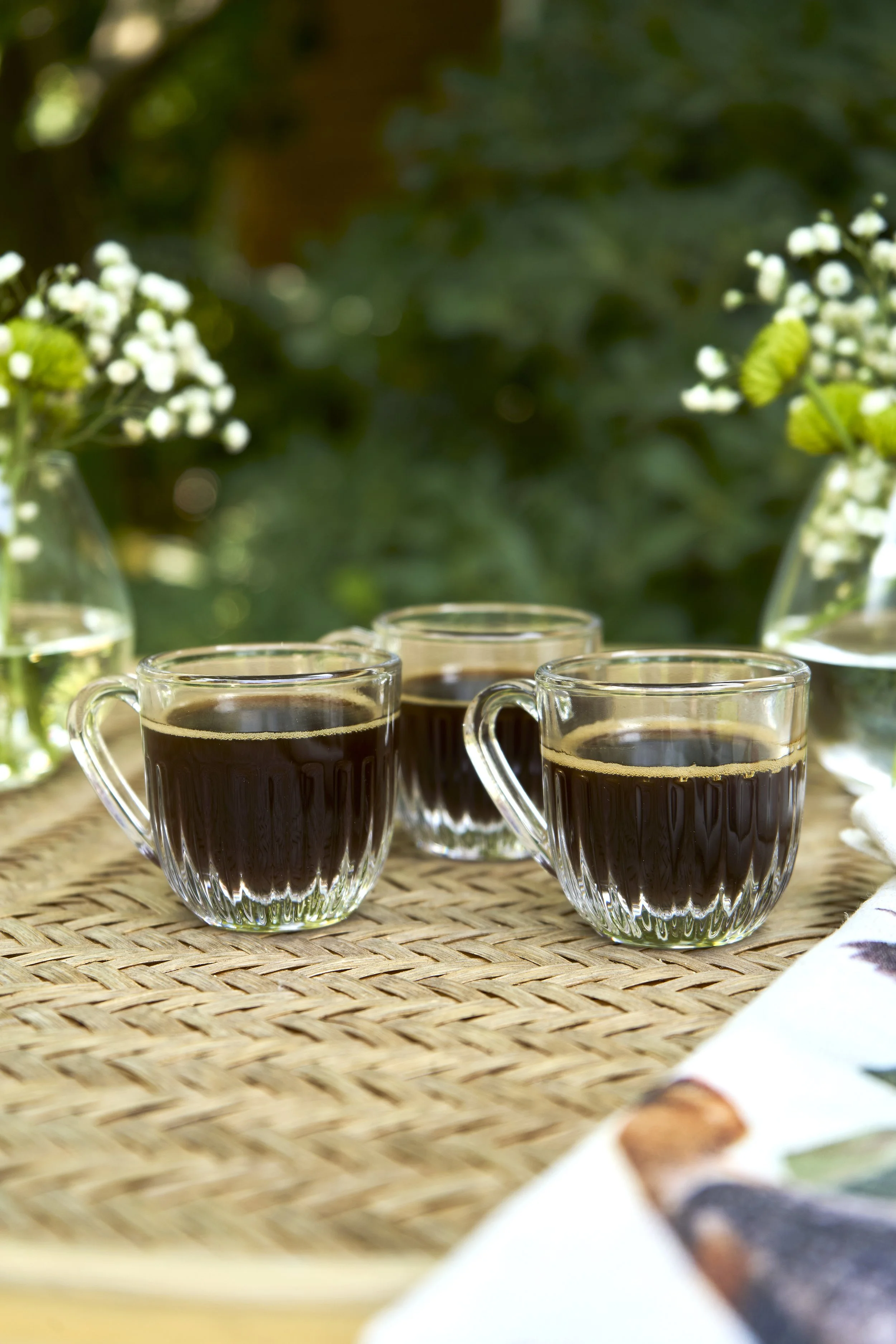 Fotografía de producto lifestyle con mesa de terraza, copas y tablas de cóctel al aire libre.
