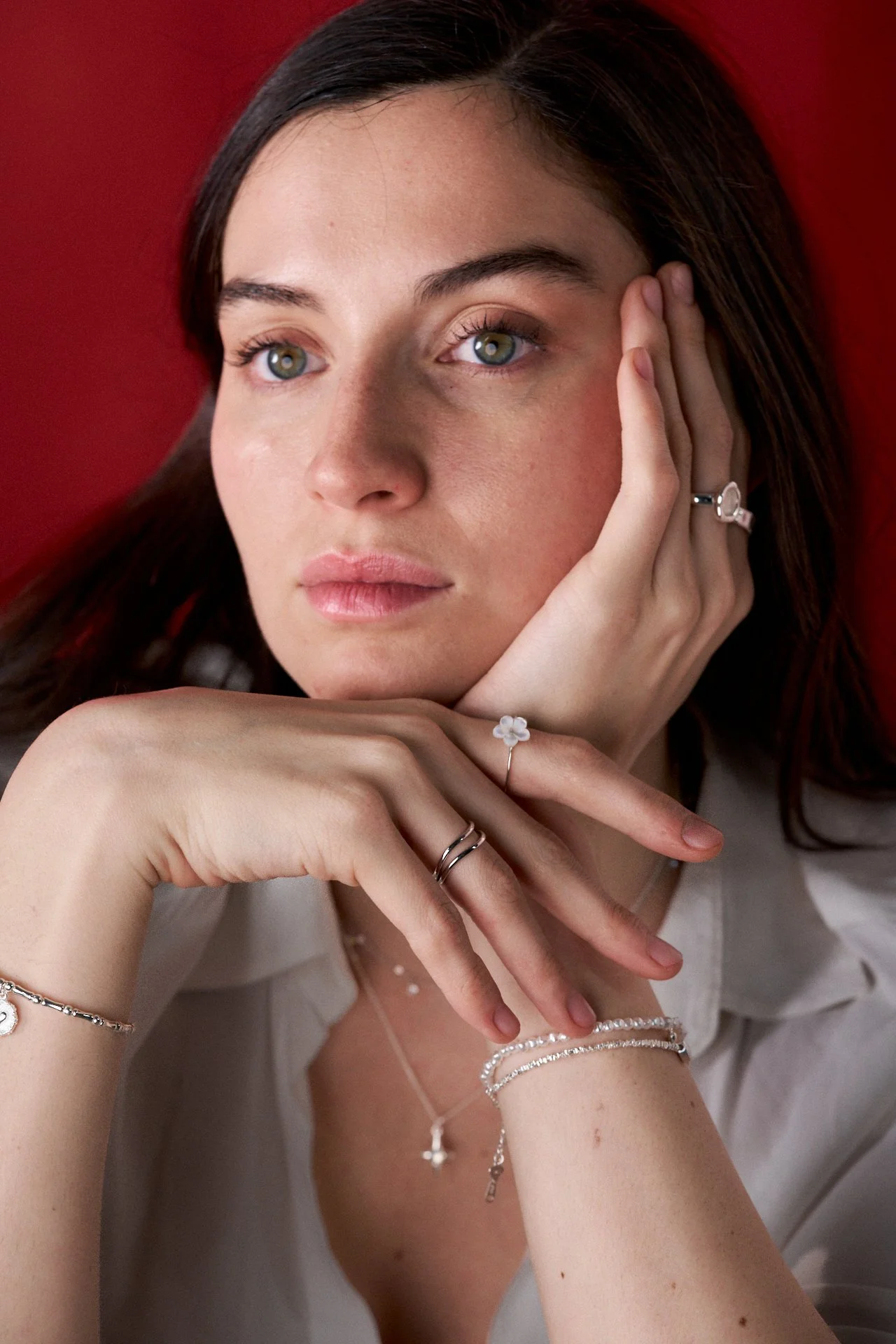 mujer modelando joyas, fotografia editorial, iluminación tenue, joyas de plata, joyas de oro