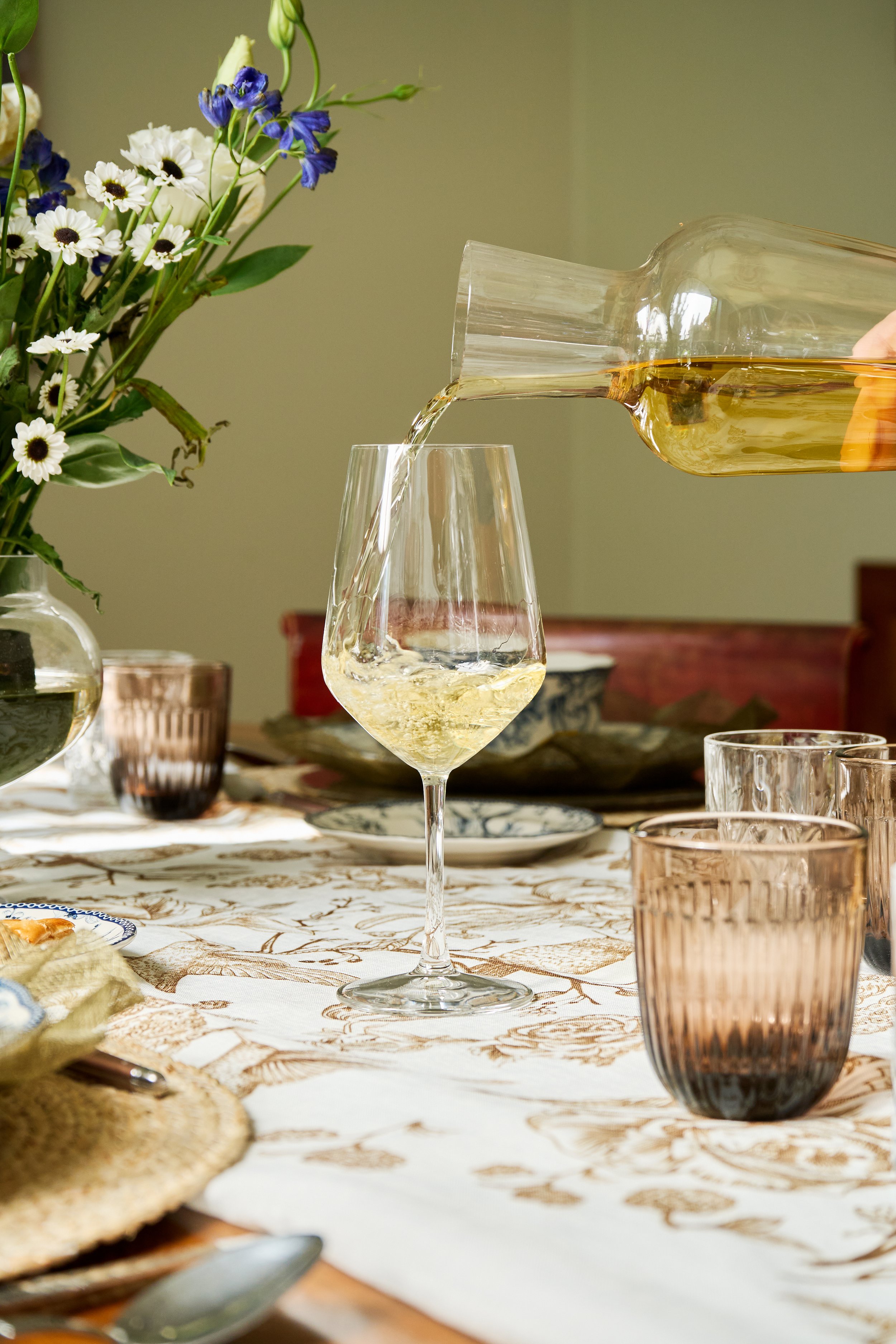 Fotografía publicitaria de menaje de lujo y botellas de vino en ambiente interior.