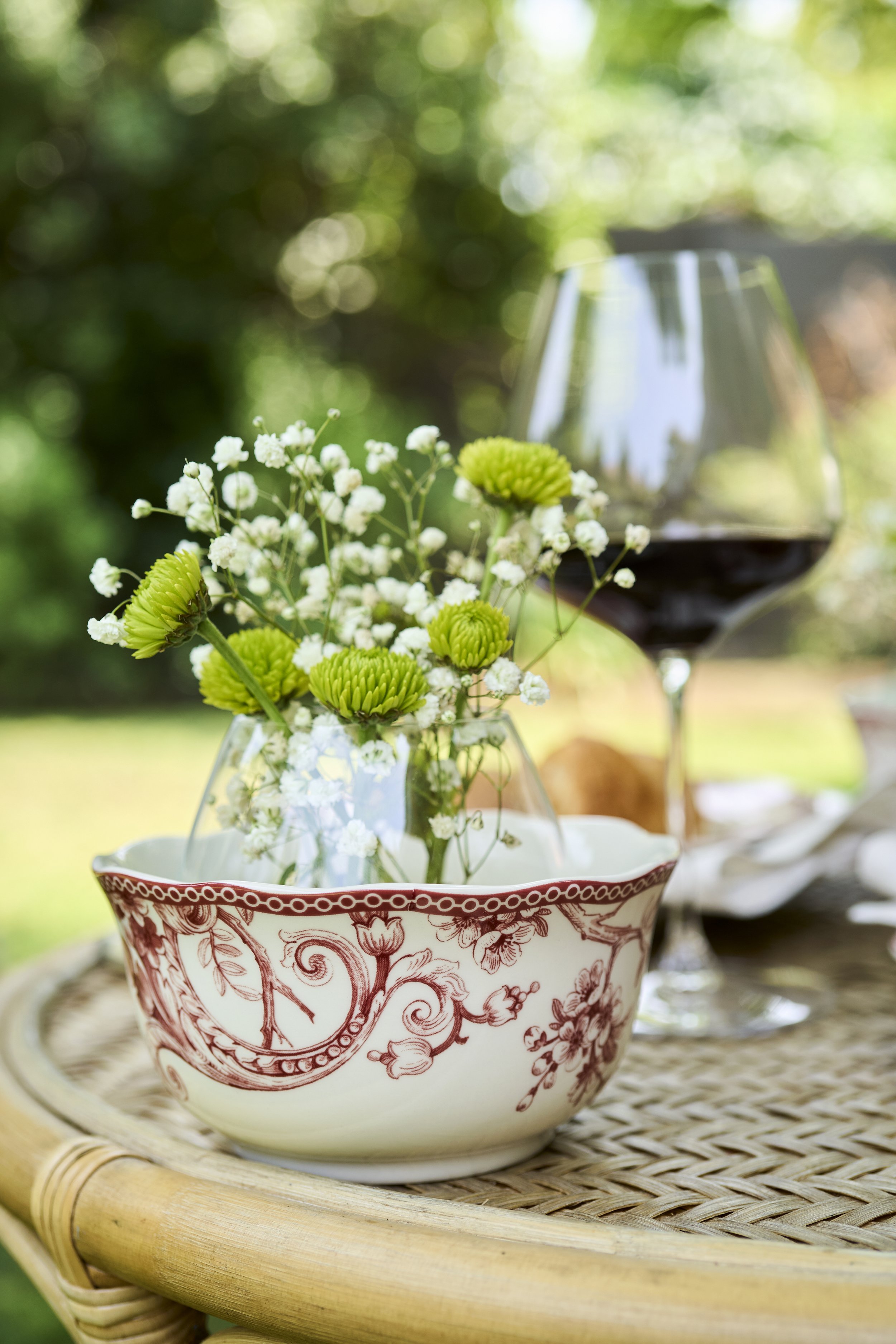 Fotografía de producto lifestyle con mesa de terraza, copas y tablas de cóctel al aire libre.