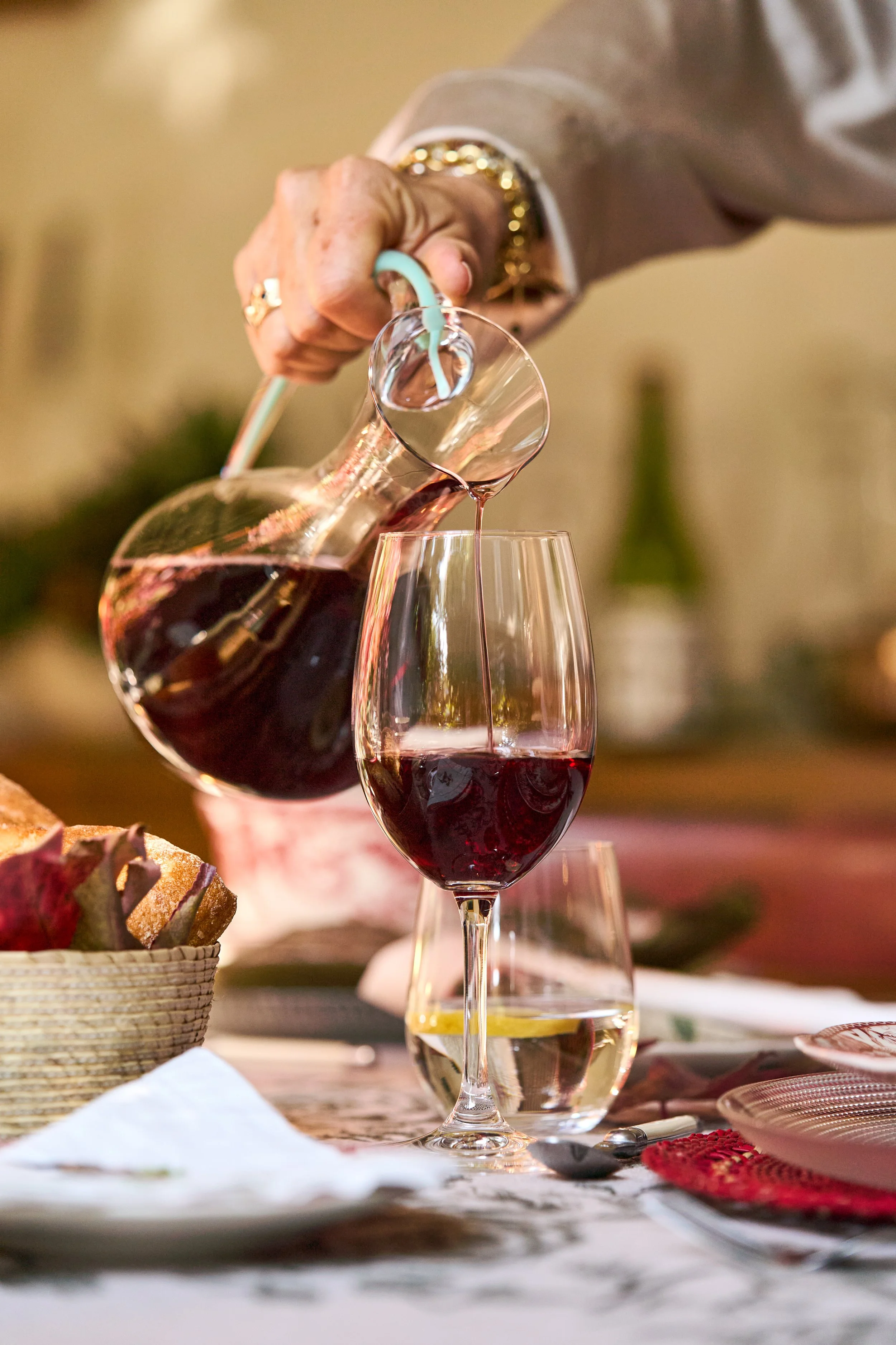 Fotografía publicitaria de menaje de lujo y botellas de vino en ambiente interior.