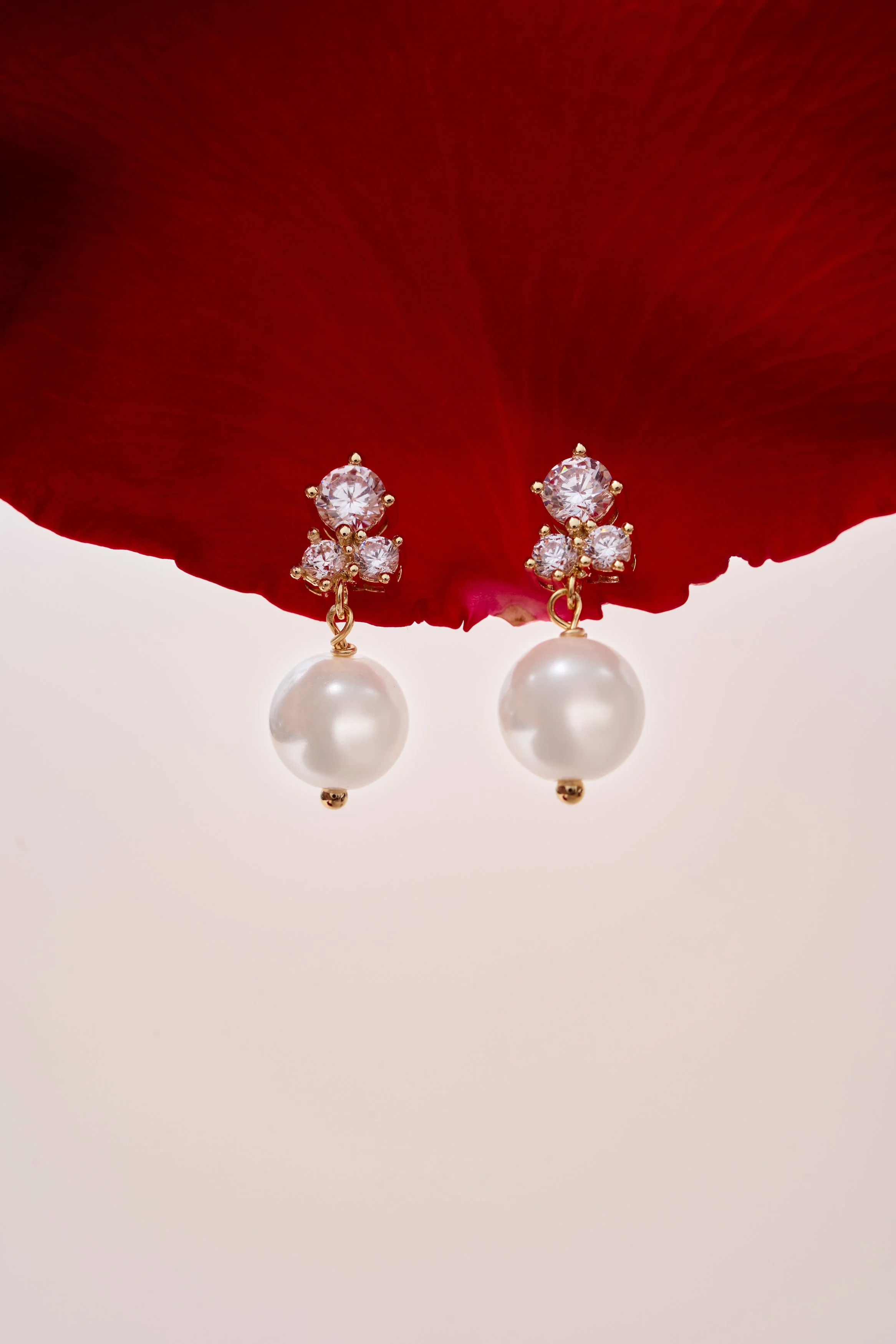 fotografia minimalista de producto, fotografía aros, fotografia joyas, dorado, aros, oro, collares, frutillas, perlas